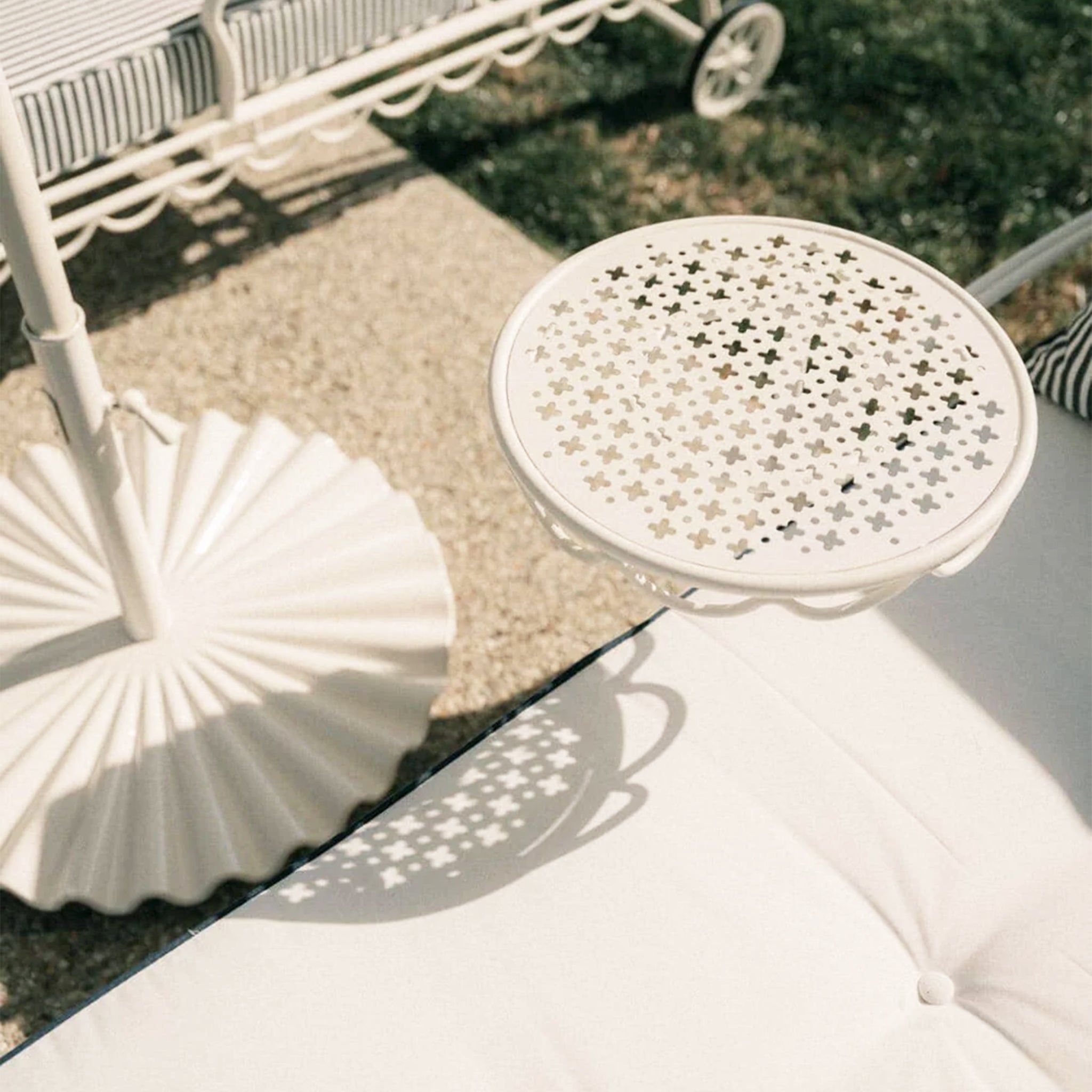 A white metal lounger with a swivel table attached. Cushions not included.