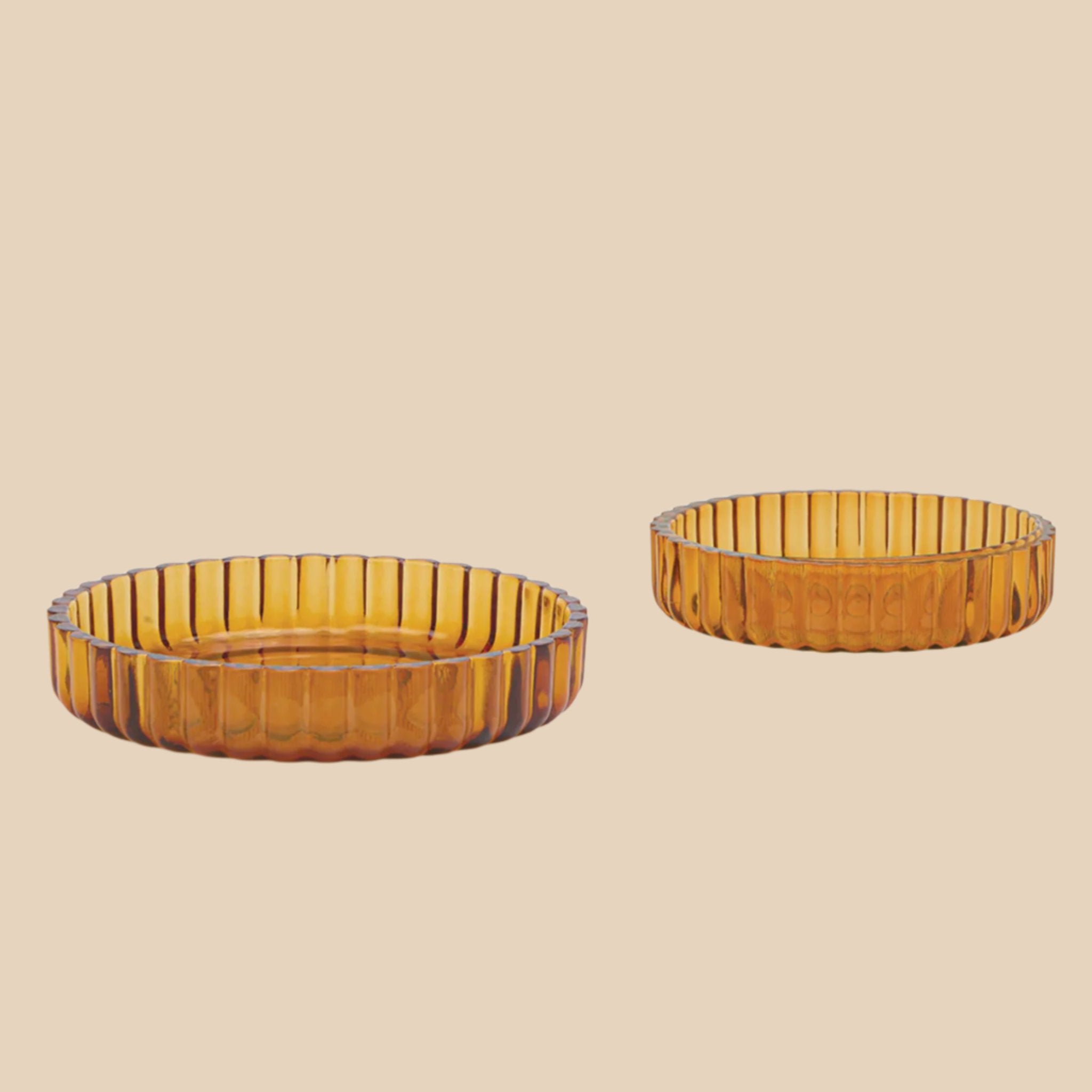 A set of two different sized amber colored ribbed tray bowls. 