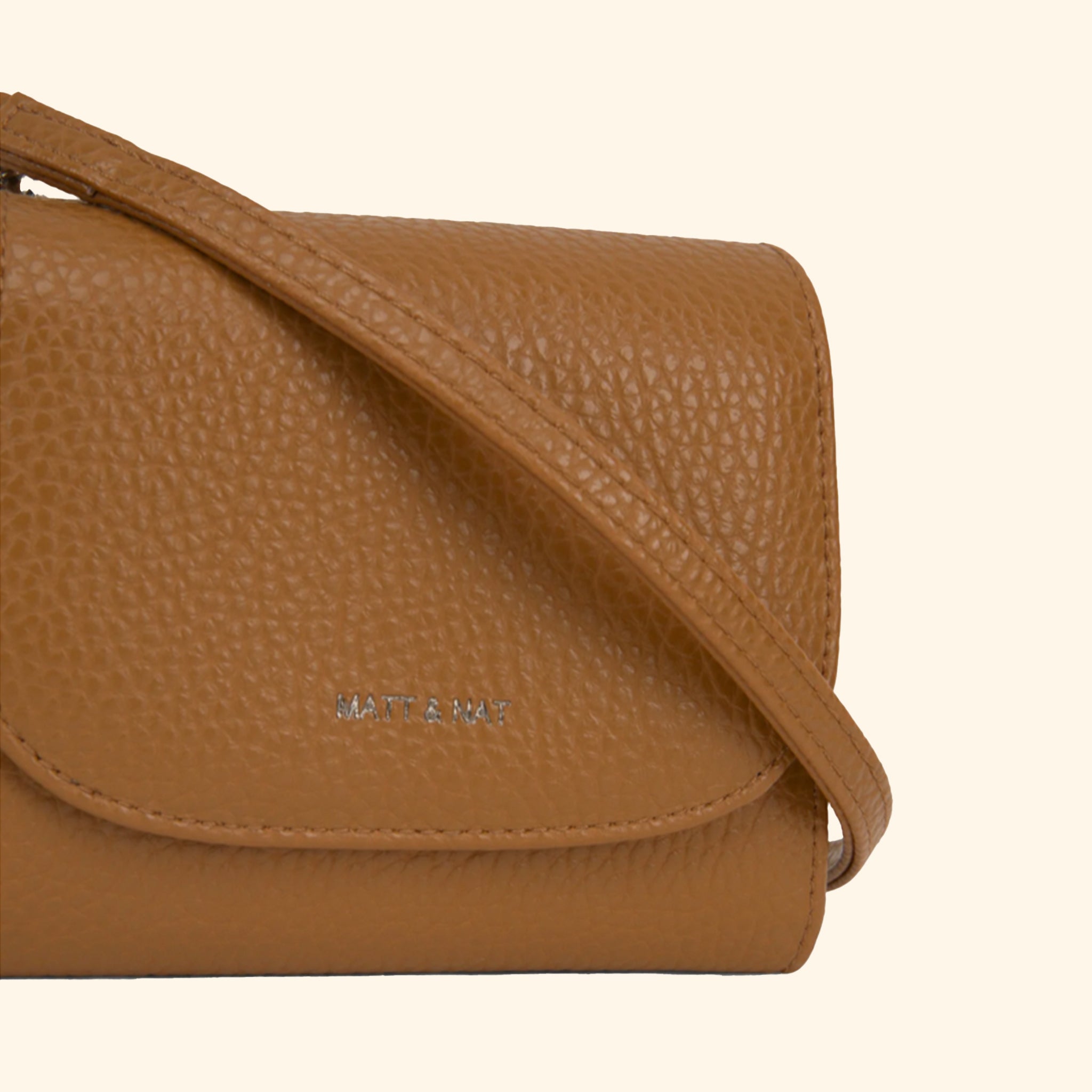 A brown wallet that also turns into a crossbody with a removable strap. 