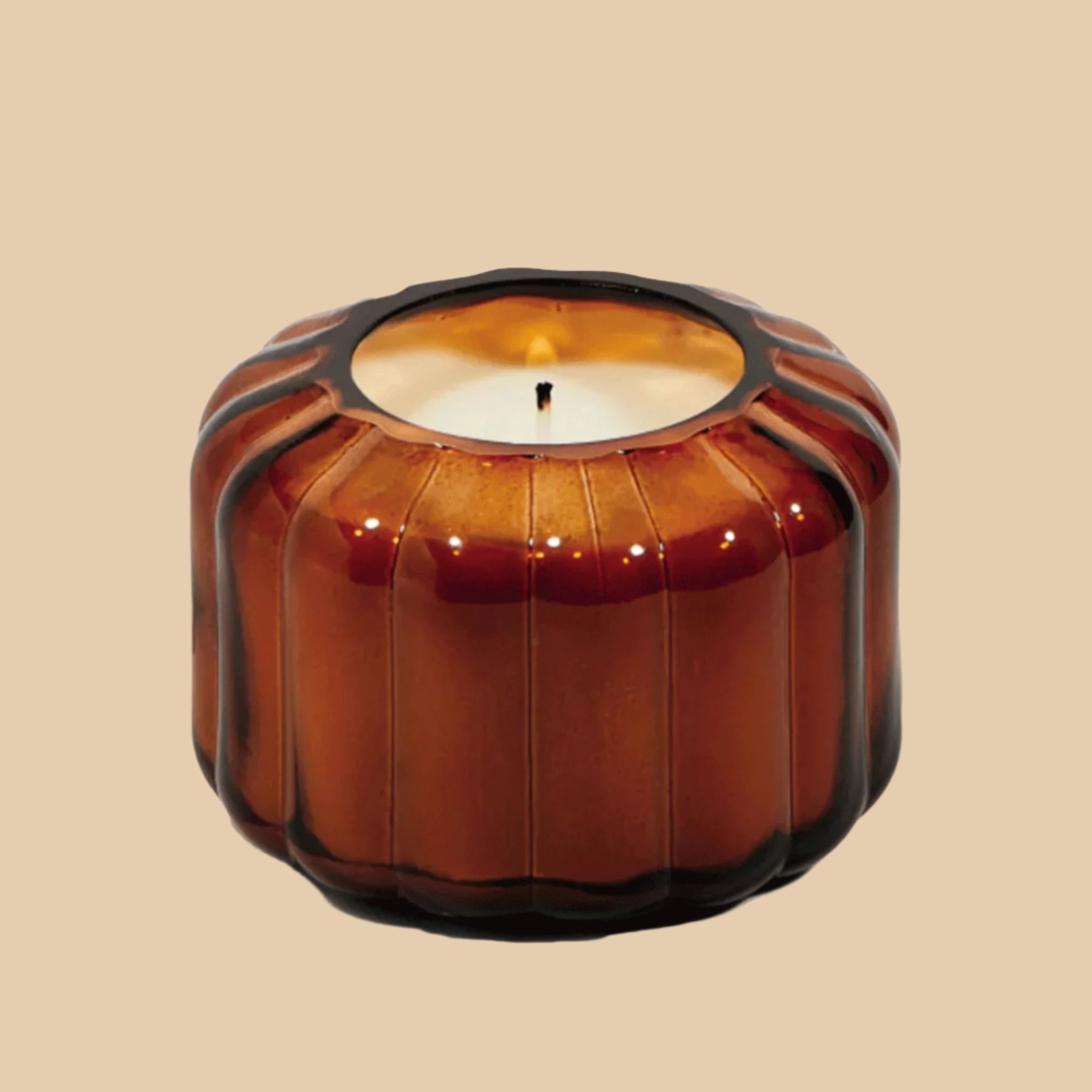 An amber glass candle with a ribbed texture and a single wick.