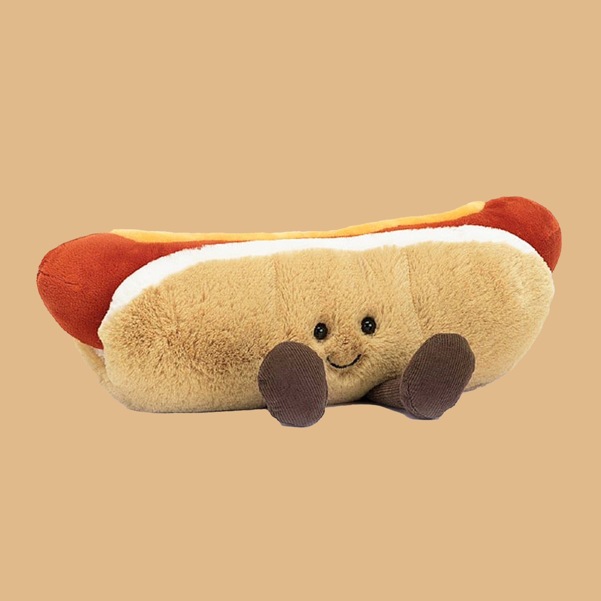 On a neutral background is an amusable hot dog stuffed animal.