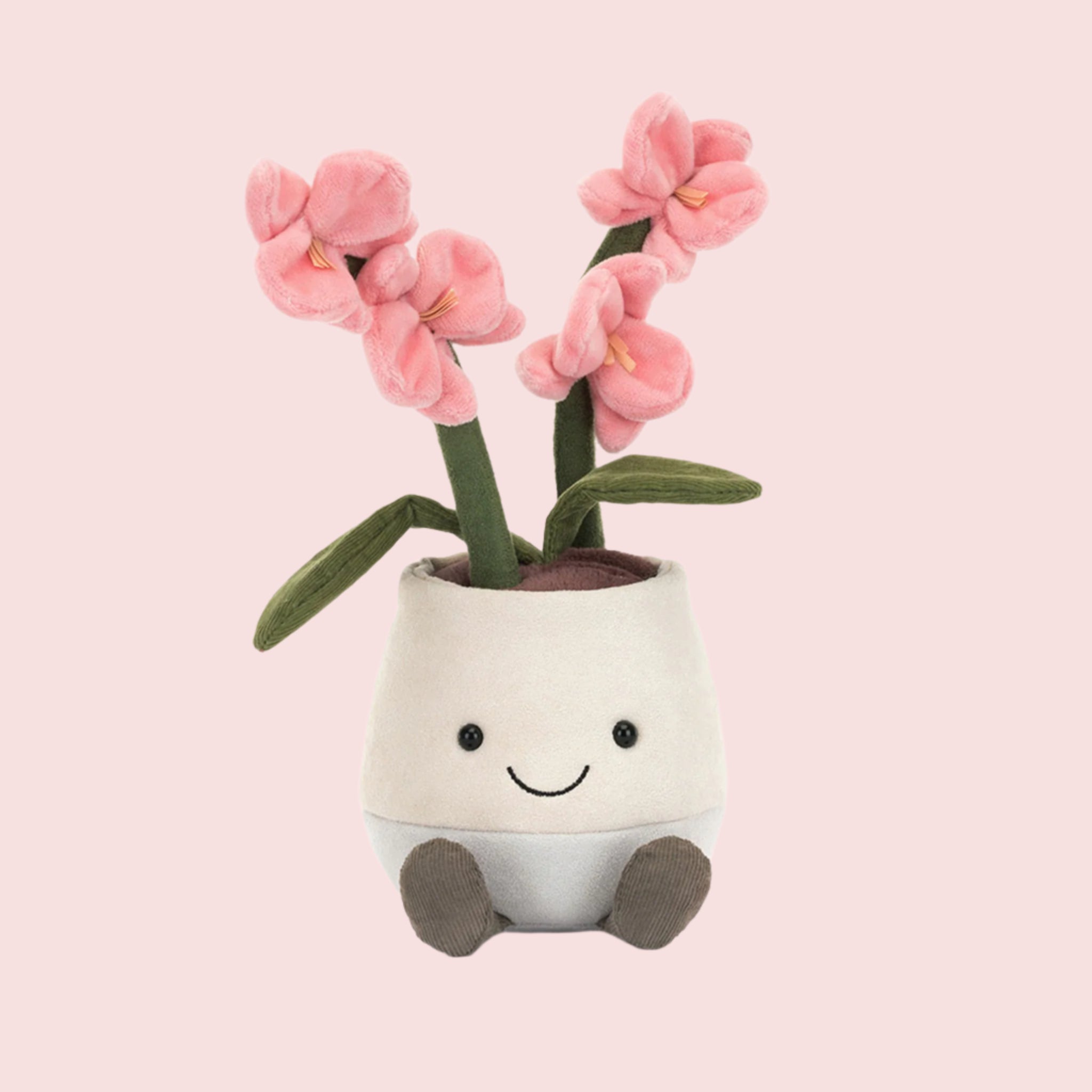 A stuffed toy in the shape of a potted pink orchid with a smiling face. 