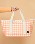 An apricot and ivory checkered print tote bag with two straps. 