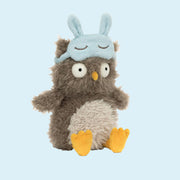 An owl shaped stuffed animal with a light blue sleeping mask.