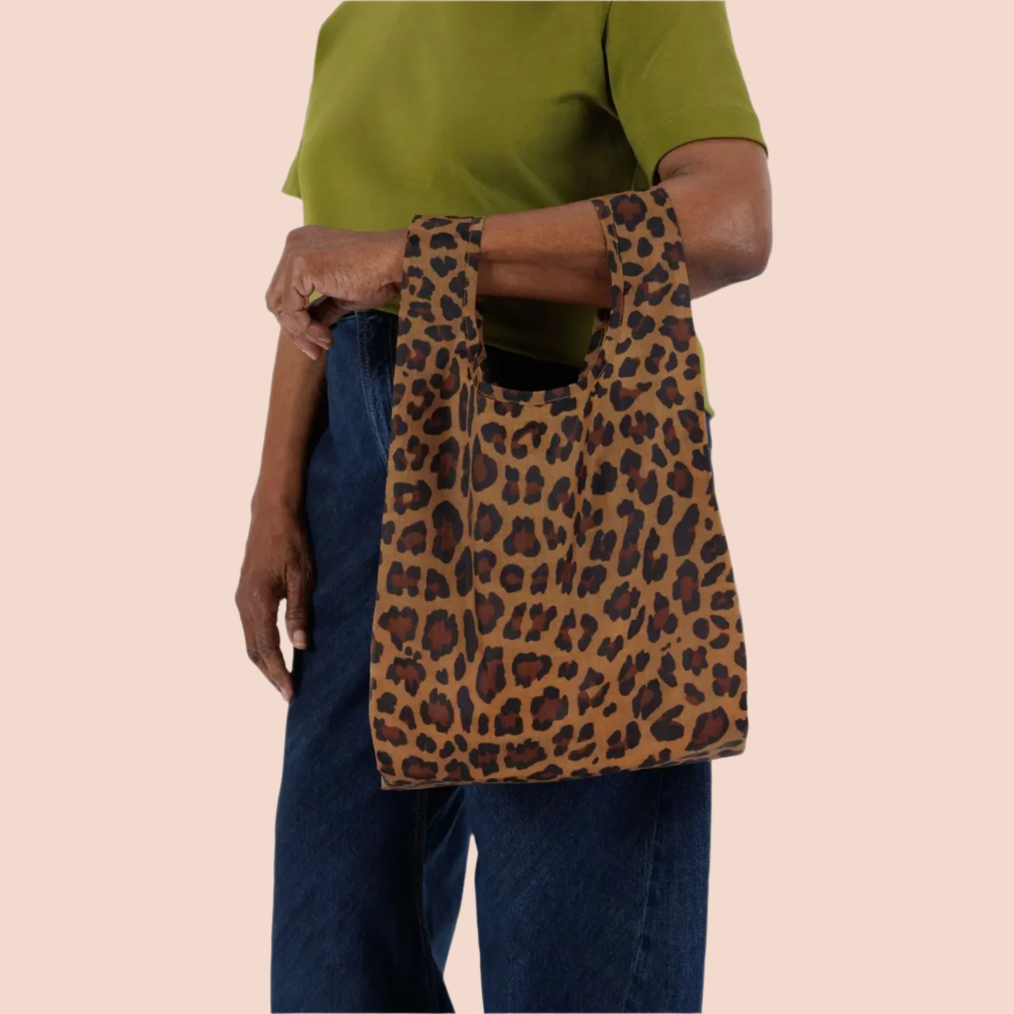 A small nylon tote bag in a leopard print that folds up into a small pouch. 