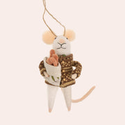 A white mouse shaped ornament wearing a cardigan and holding a pack of baguettes. 