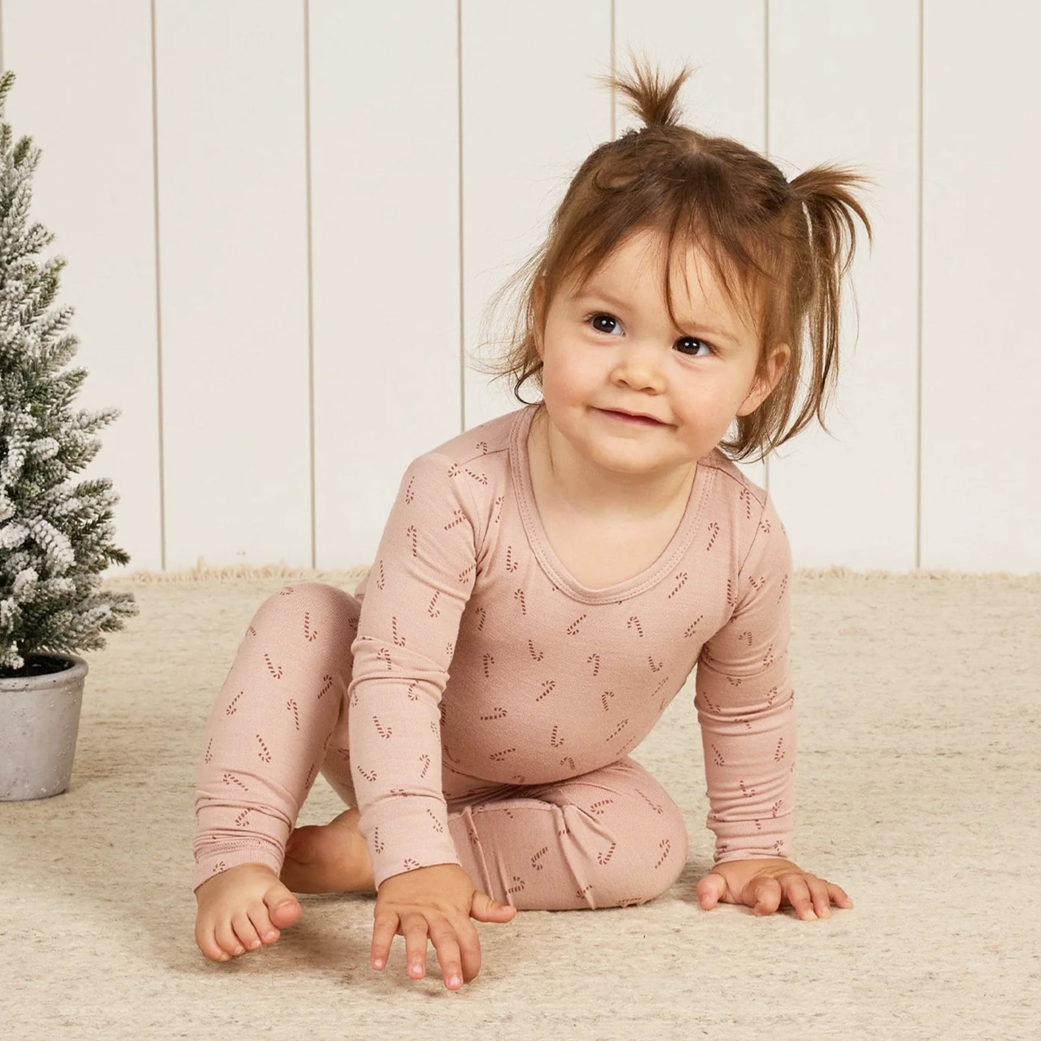 A pink pajama set with a candy cane print. 