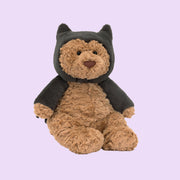 A brown bear stuffed animal wearing a black bat costume. 