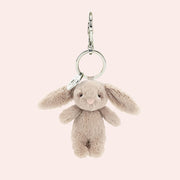 A beige small bunny shaped bag charm keychain. 