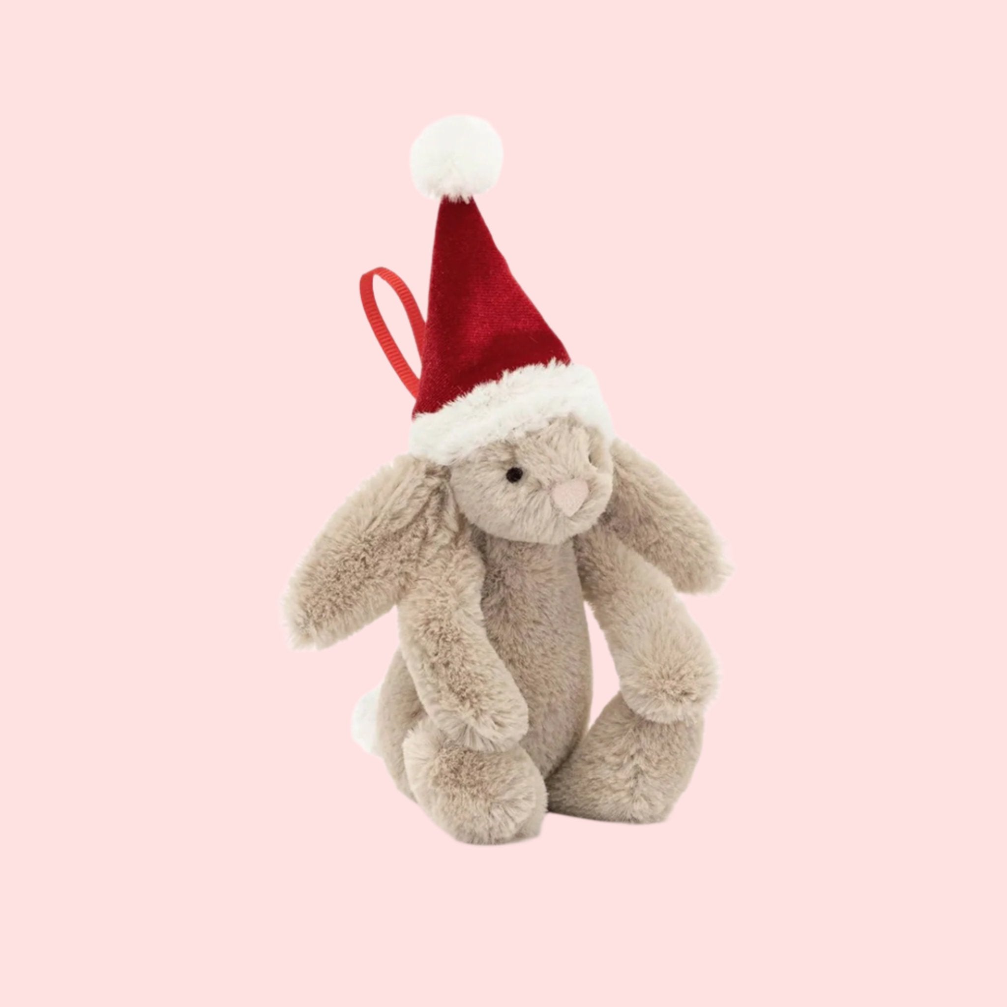 A bunny shaped ornament with a red Santa hat and a red loop for hanging.