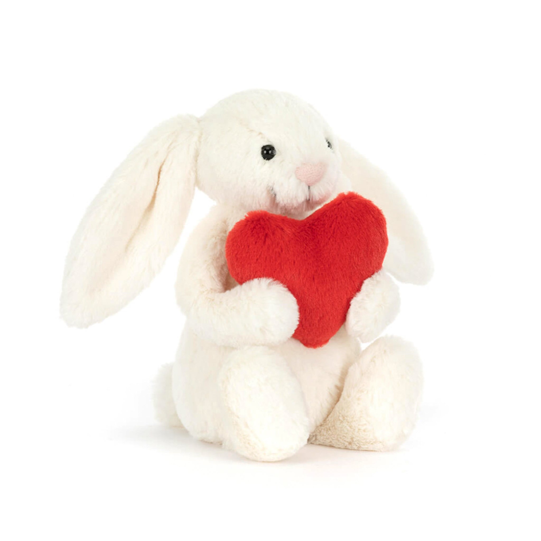 A white bunny stuffed toy holding a red heart. 