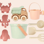 A set of beach toys in the shape of crabs, octopus, dump trucks along with a shovel, sand tools, bucket and watering can. 