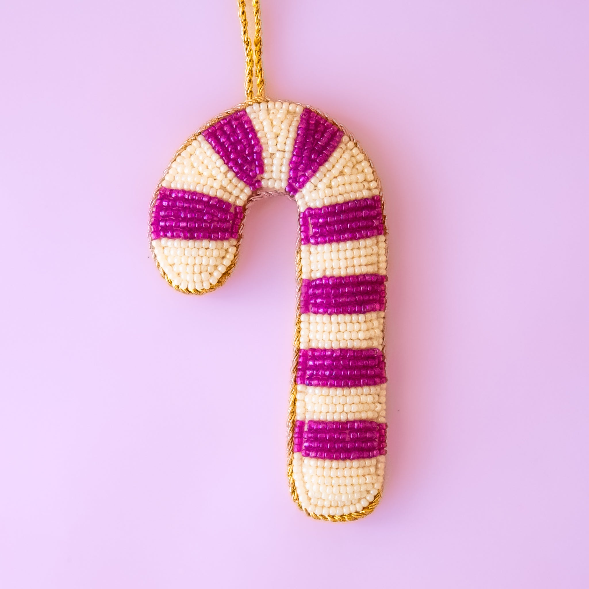 A fuchsia and ivory beaded candy cane shaped ornament. 