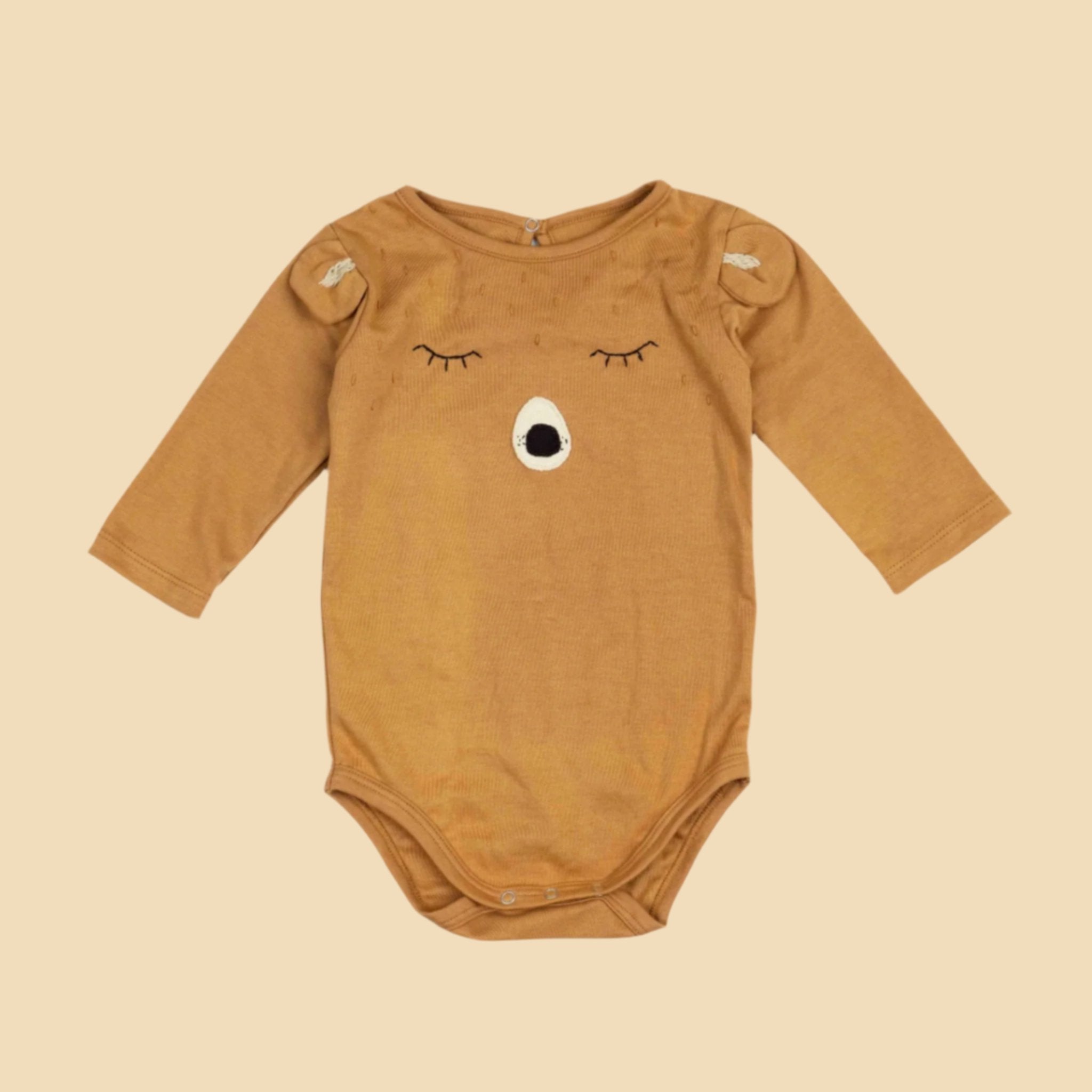 A long sleeve onesie with a bear face on the front. 