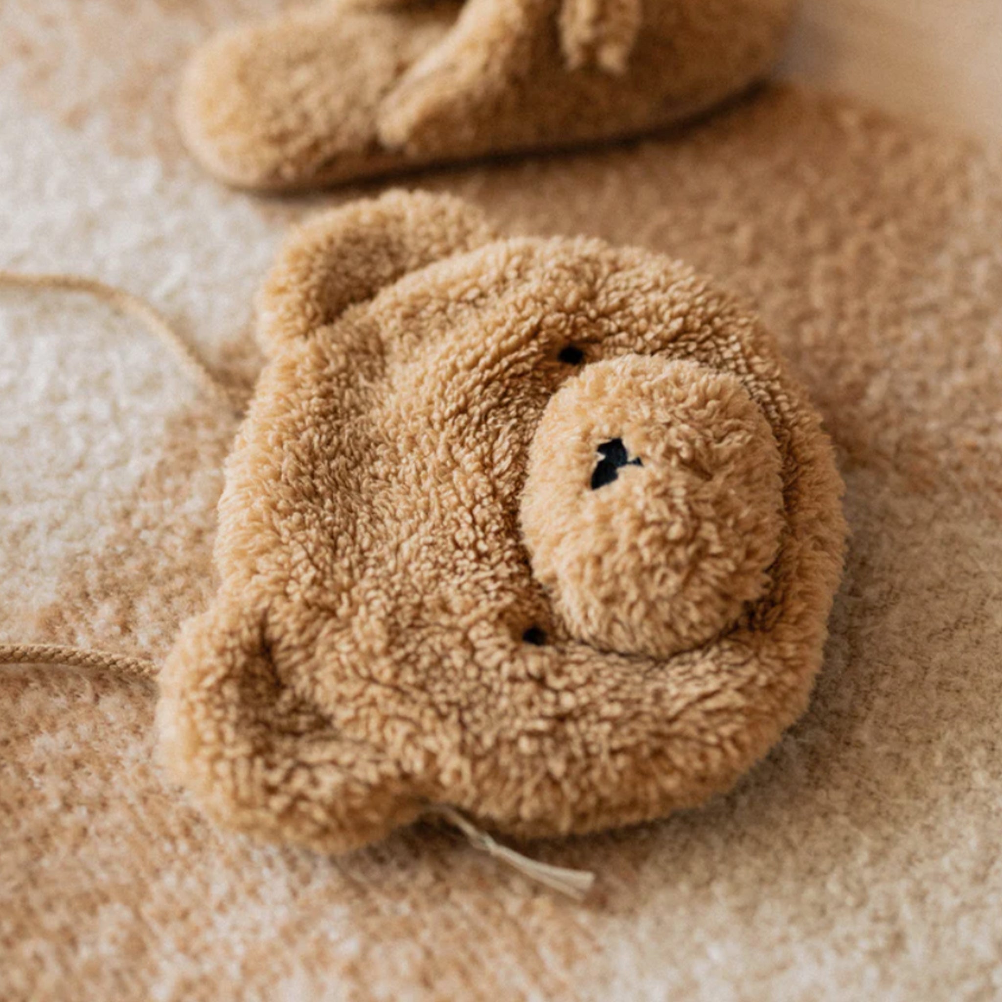 A brown fuzzy purse with a long shoulder strap.