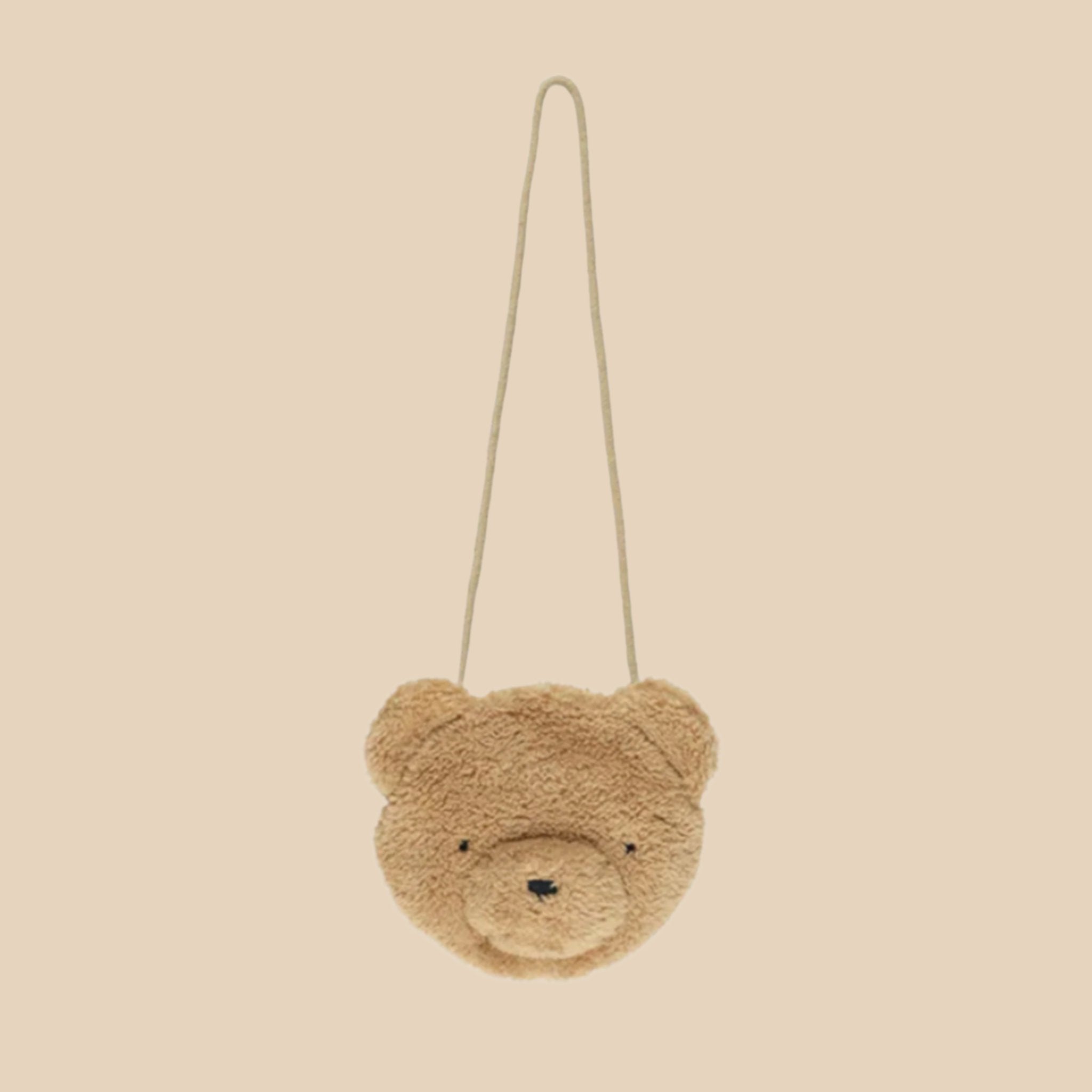 A brown fuzzy purse with a long shoulder strap. 