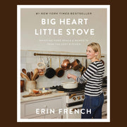 A neutral colored bookcover with a photo of a woman cooking in front of the stove with the title toward the top that reads, "Big Heart Little Stove Bringing Home Meals & Moments From The Lost Kitchen". 