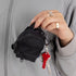 A black mini backpack bag charm. 