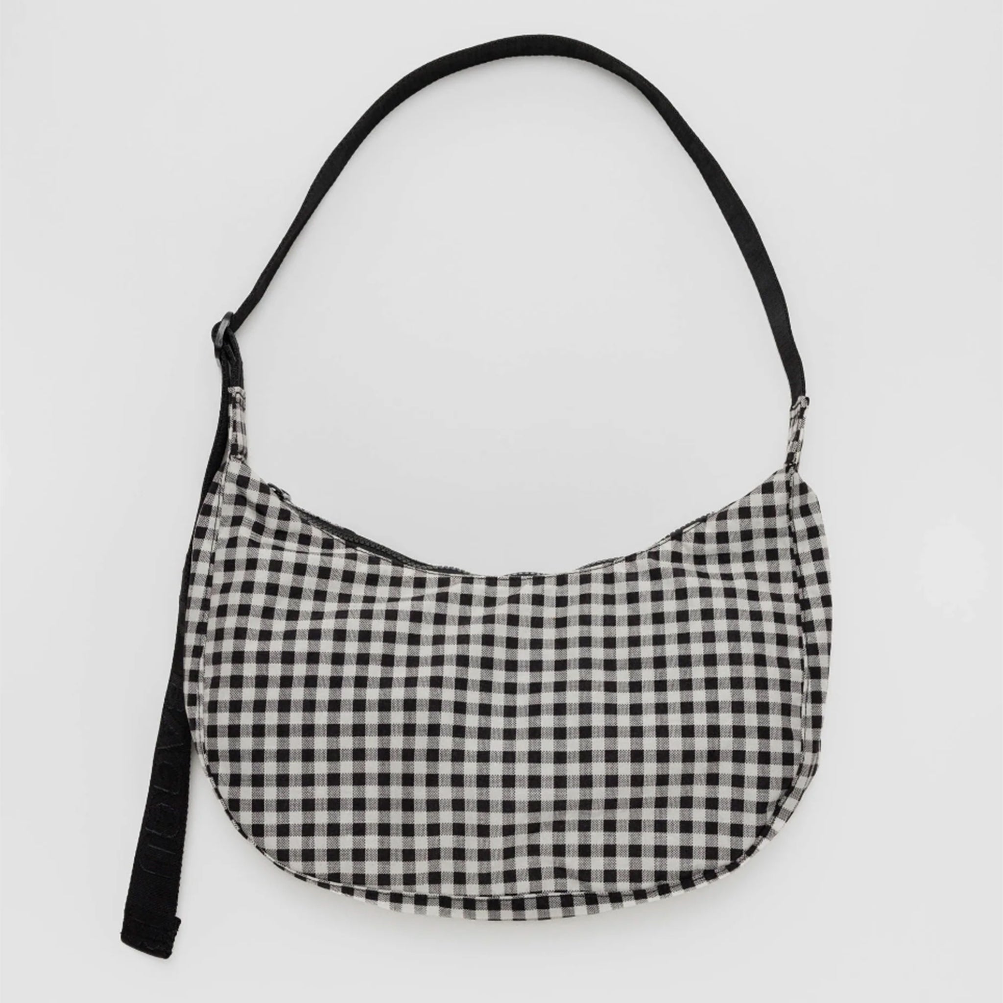 A black and white gingham printed crescent shaped nylon handbag with a black adjustable strap that can go from a shoulder bag to crossbody.