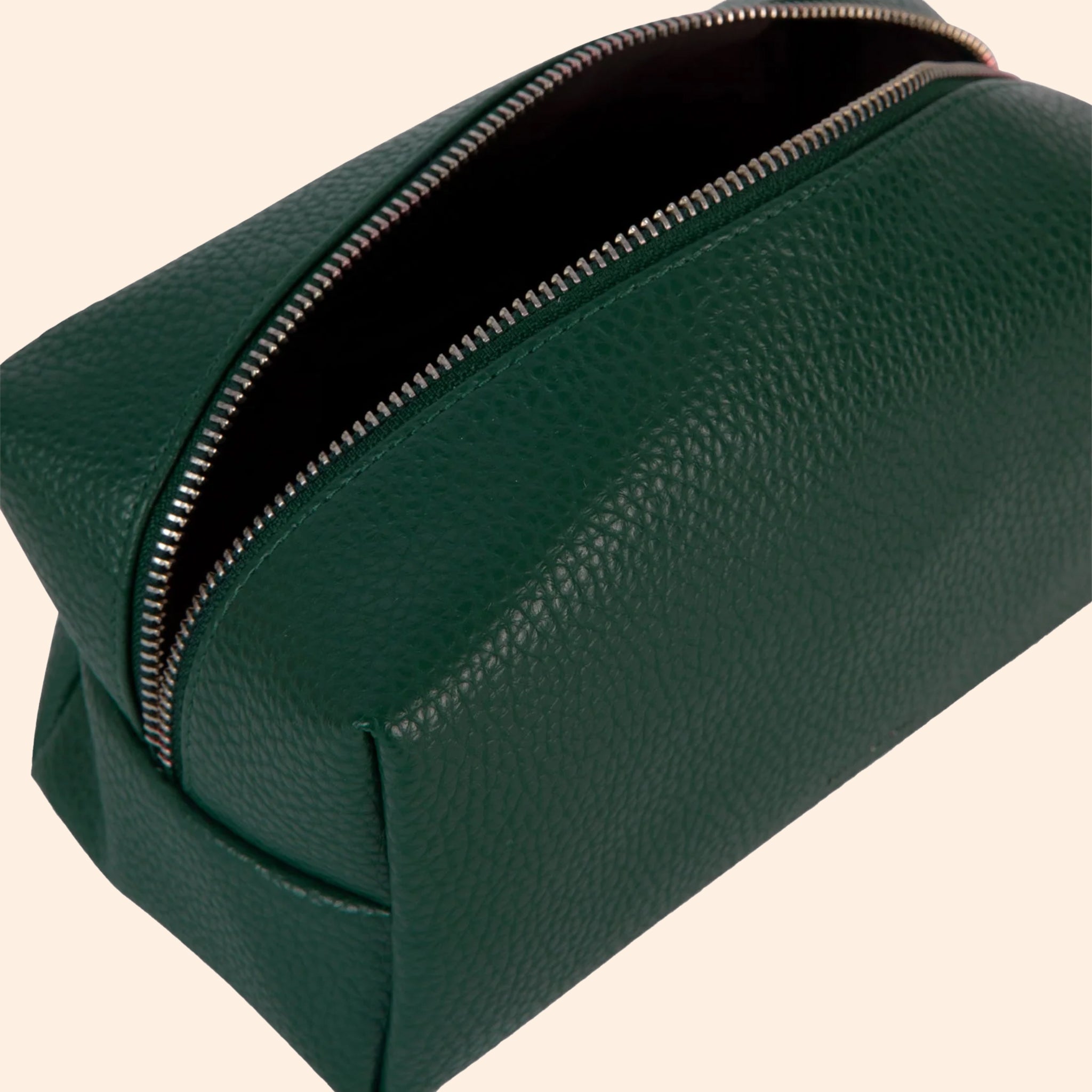 An emerald green vegan leather cosmetic case with a zipper closure. 