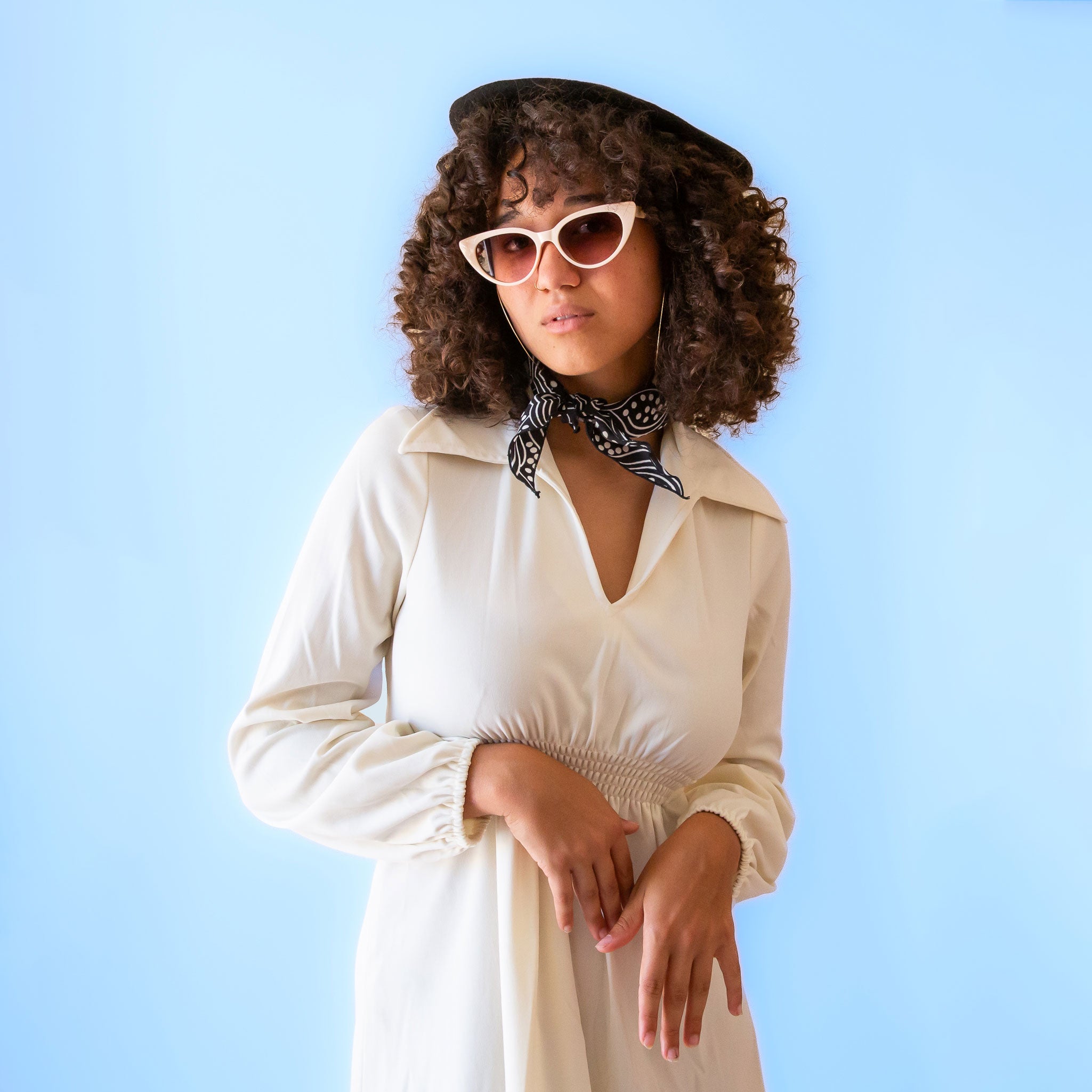 A pair of ivory cat-eye shaped sunglasses. 