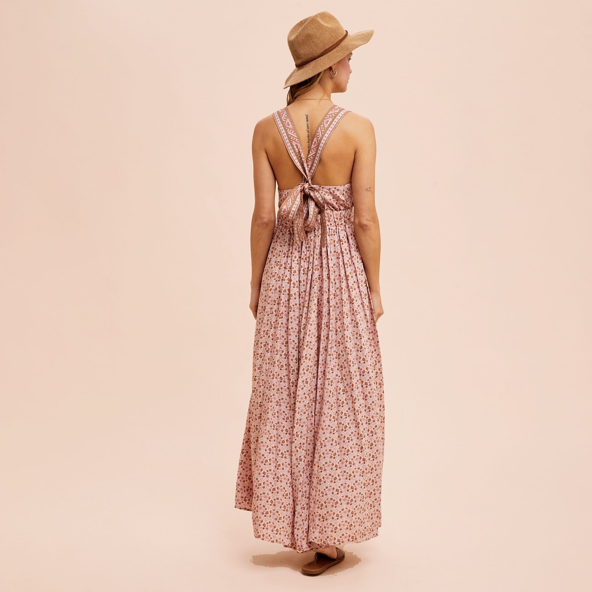 A dusty pink floral maxi dress with a v-neckline and a small slit at the bottom. 