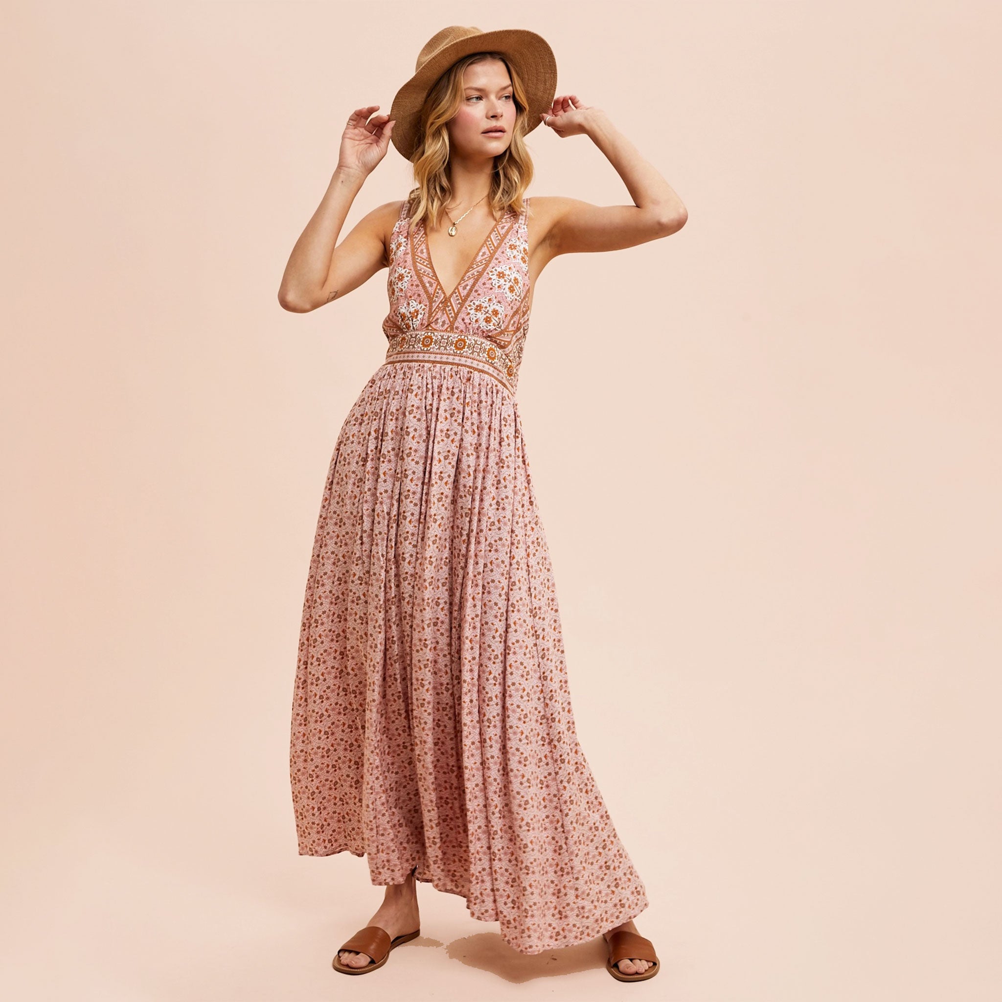 A dusty pink floral maxi dress with a v-neckline and a small slit at the bottom. 