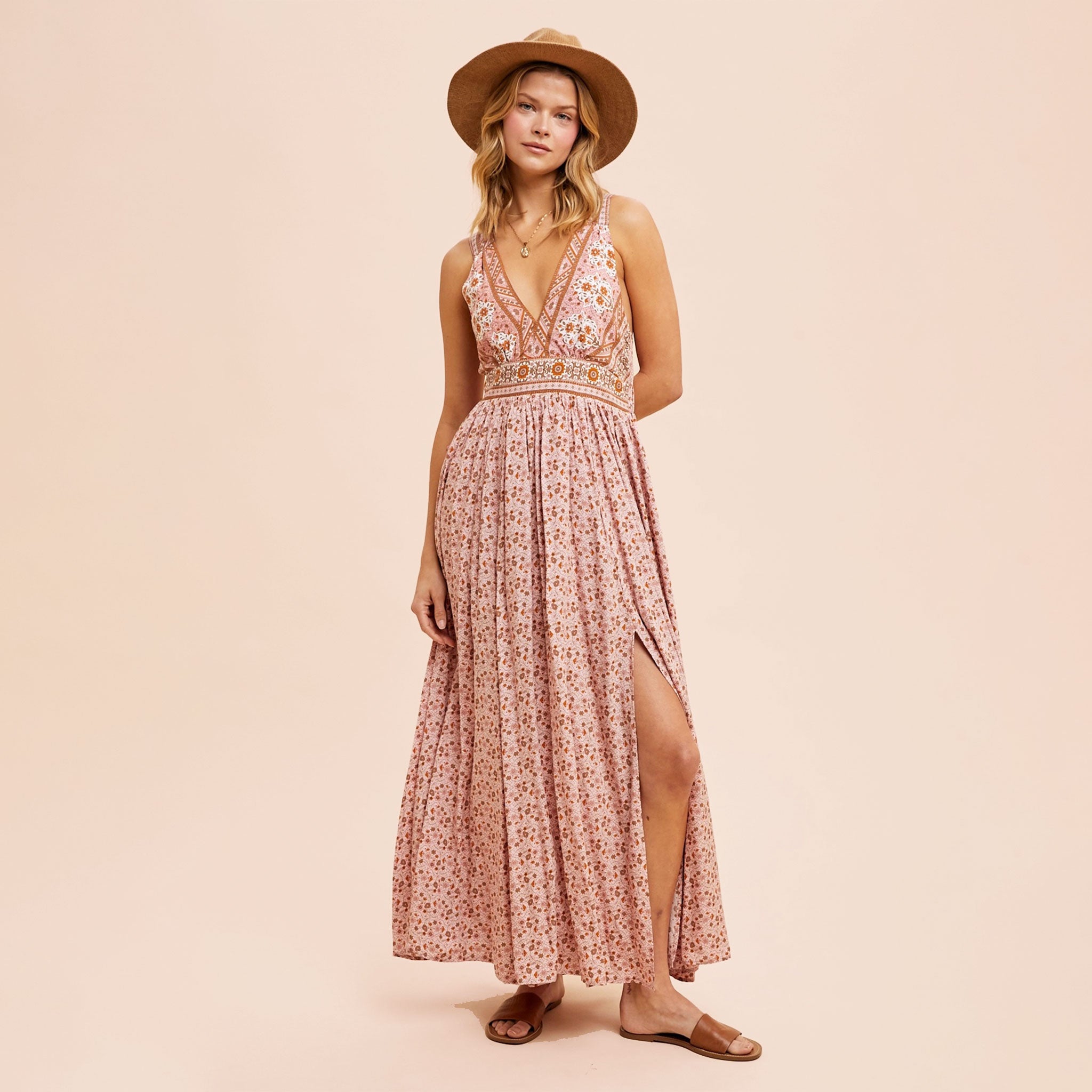 A dusty pink floral maxi dress with a v-neckline and a small slit at the bottom. 