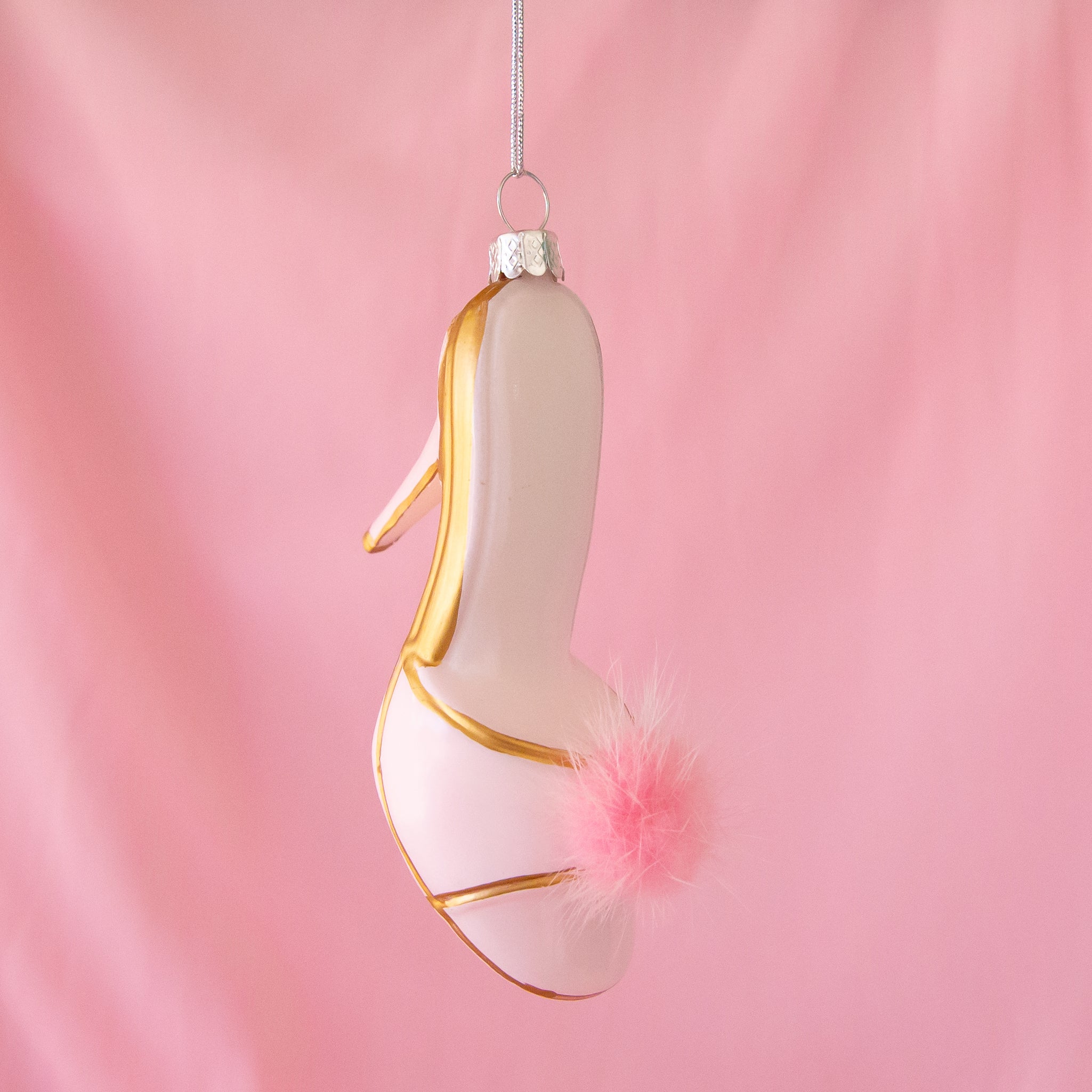 A glass mule heel shaped ornament with a pink fuzzy detail. 