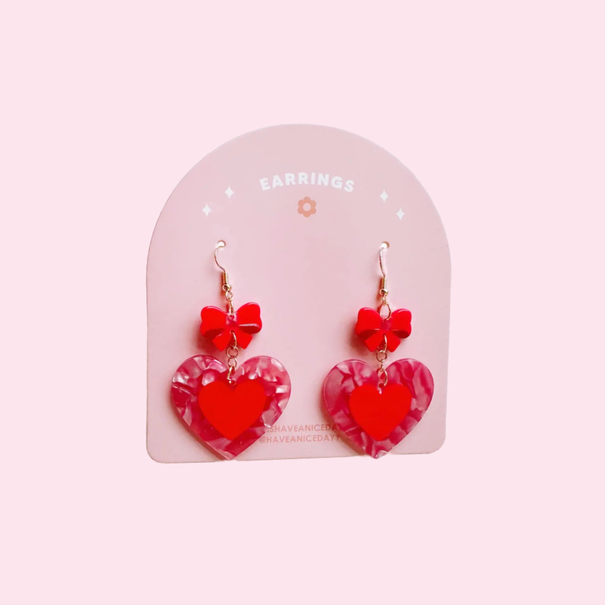 A pair of red heart and bow shaped dangle earrings. 