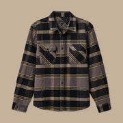 On a tan background is a black, tan and brown flannel with front pockets and buttons on the front. 