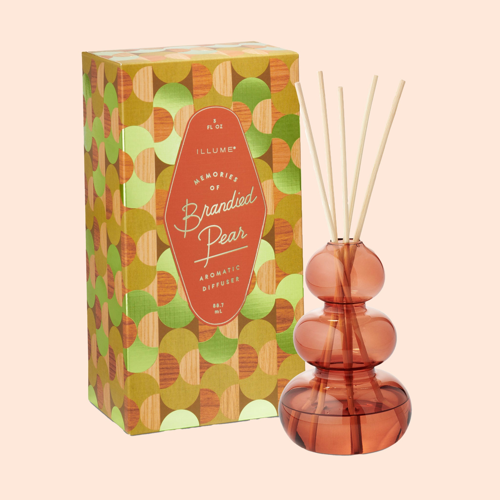 A reddish orange glass bubble shaped diffuser with wooden reeds. 