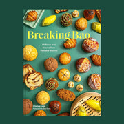 A green book cover with a variety of Asian snacks and baking items with text that reads, 'Breaking Bao'.