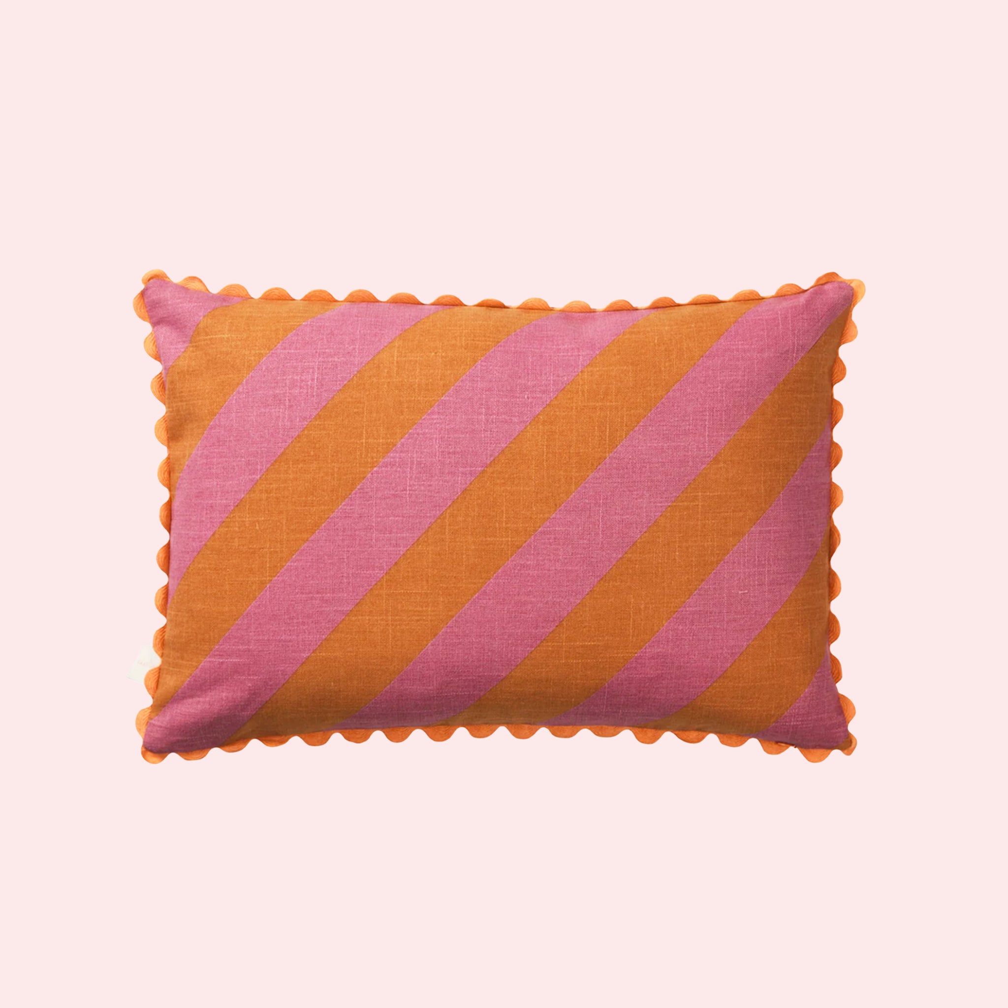 A pink and orange striped pillow with a smaller stripe on the other side and a scalloped edge. 