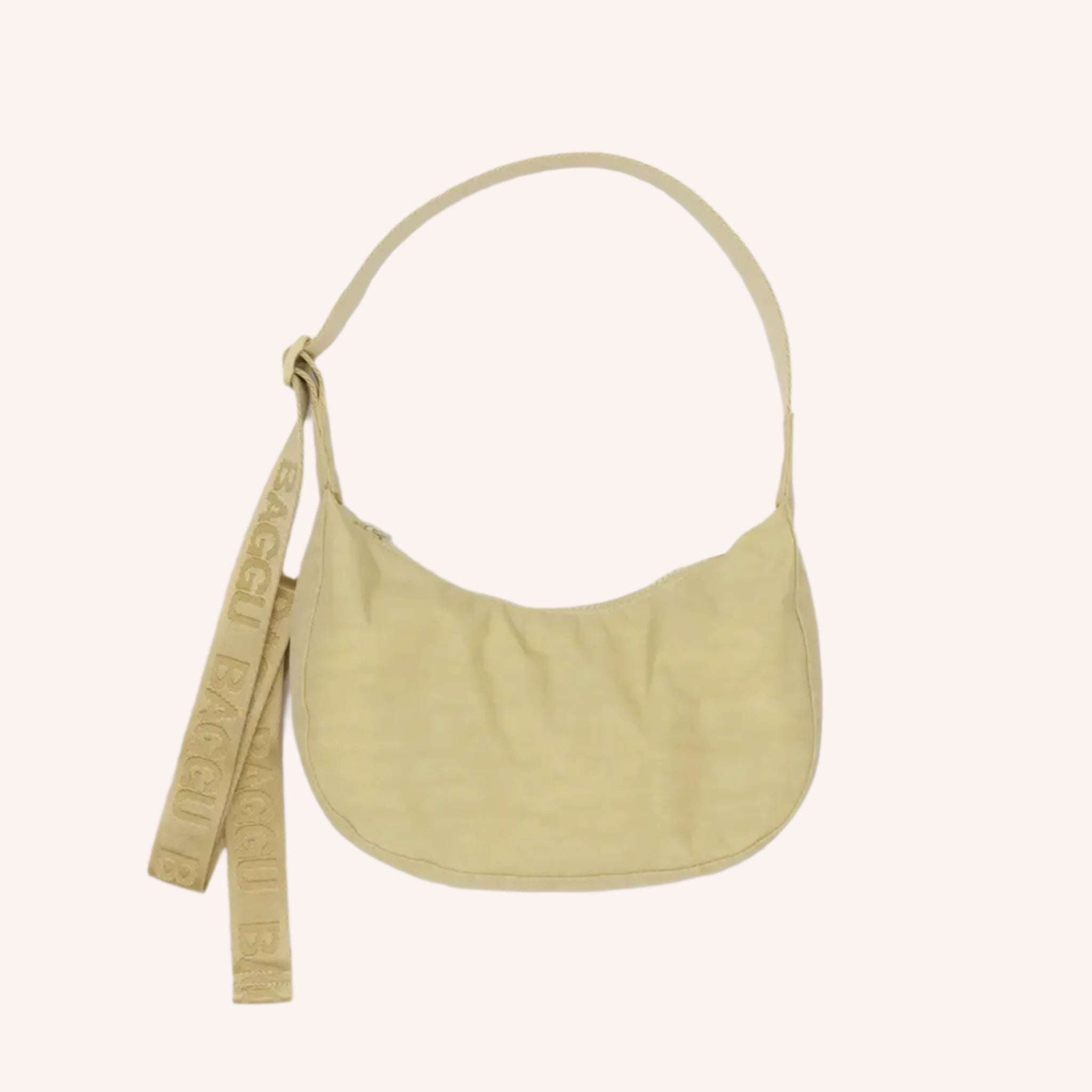 A light yellow crescent shaped nylon handbag with an adjustable strap. 