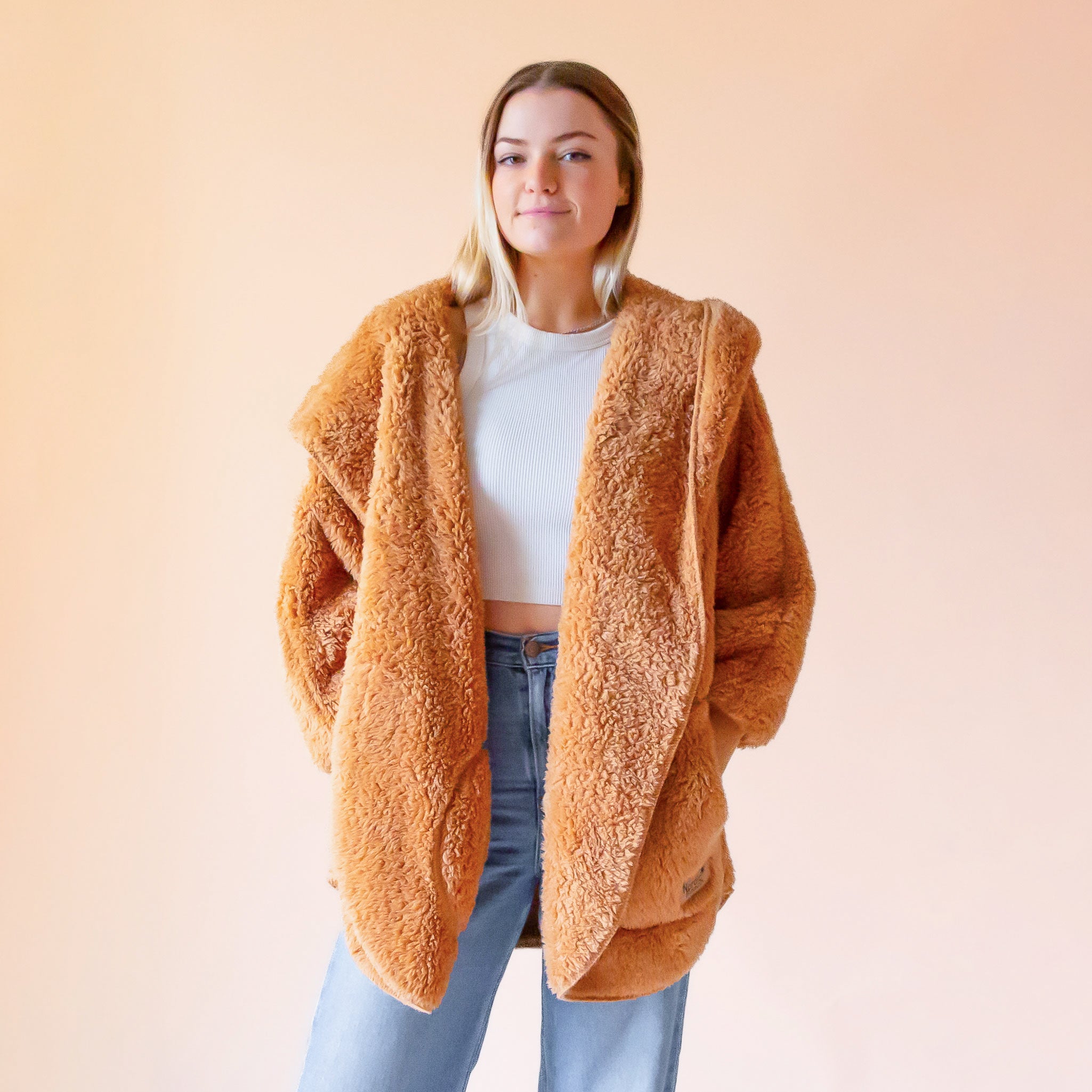 A light tan fuzzy sweater wrap.