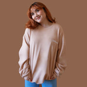 On a brown background is a peachy fleece pullover with white "California" embroidering.