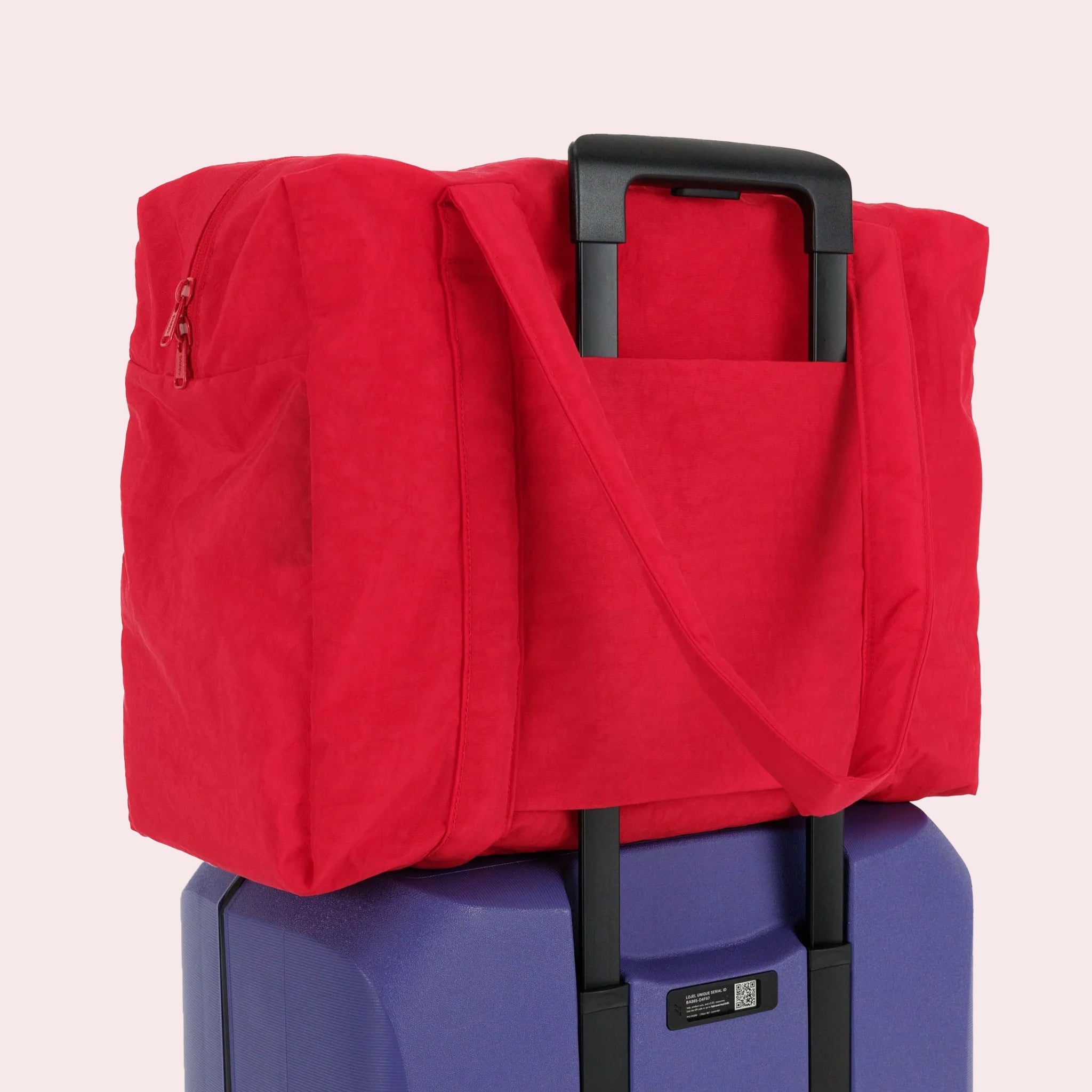A red nylon carry on tote bag with two handles and a zipper top.