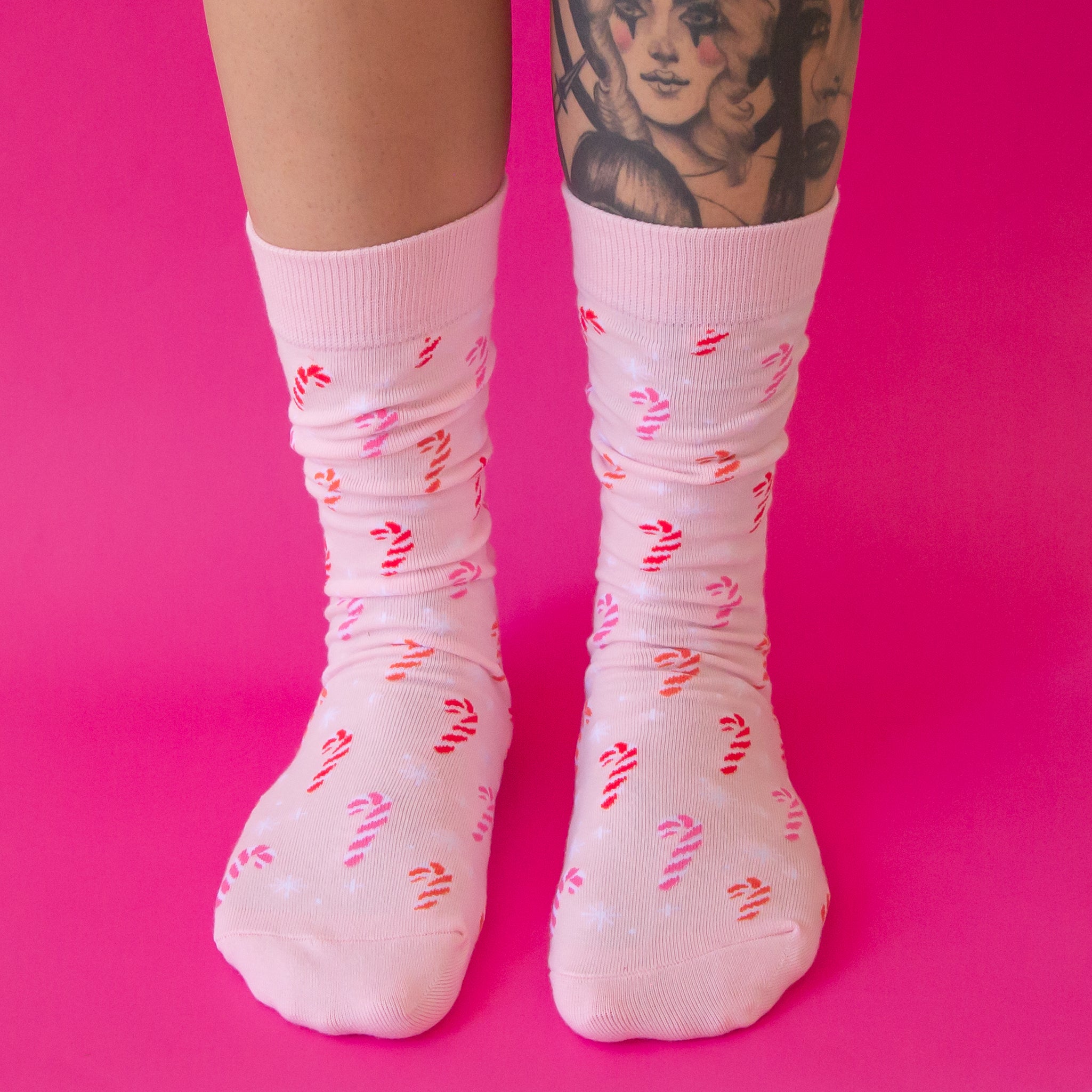 A pair of pink crew socks with a pink cotton candy pattern. 