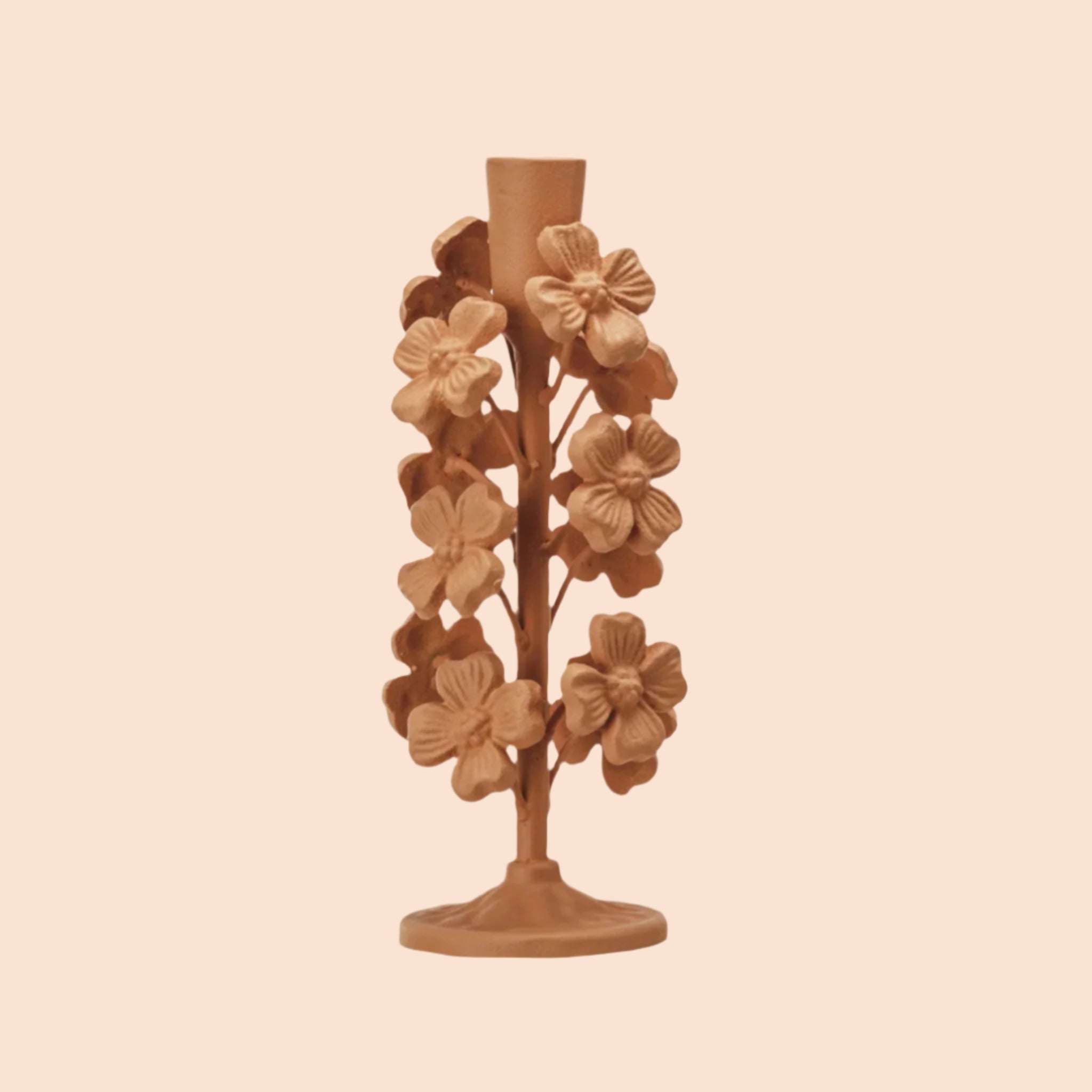 A apricot colored cast iron flower shaped taper candle holder. 