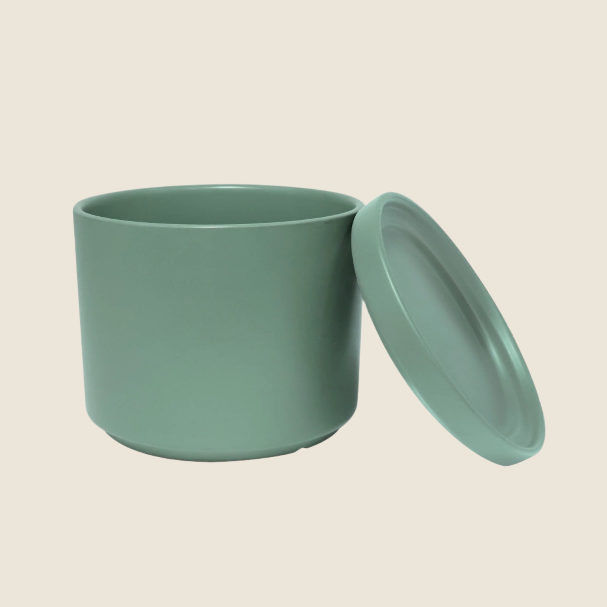 A green ceramic cylinder planter with removable saucers. Each planter sold separately.