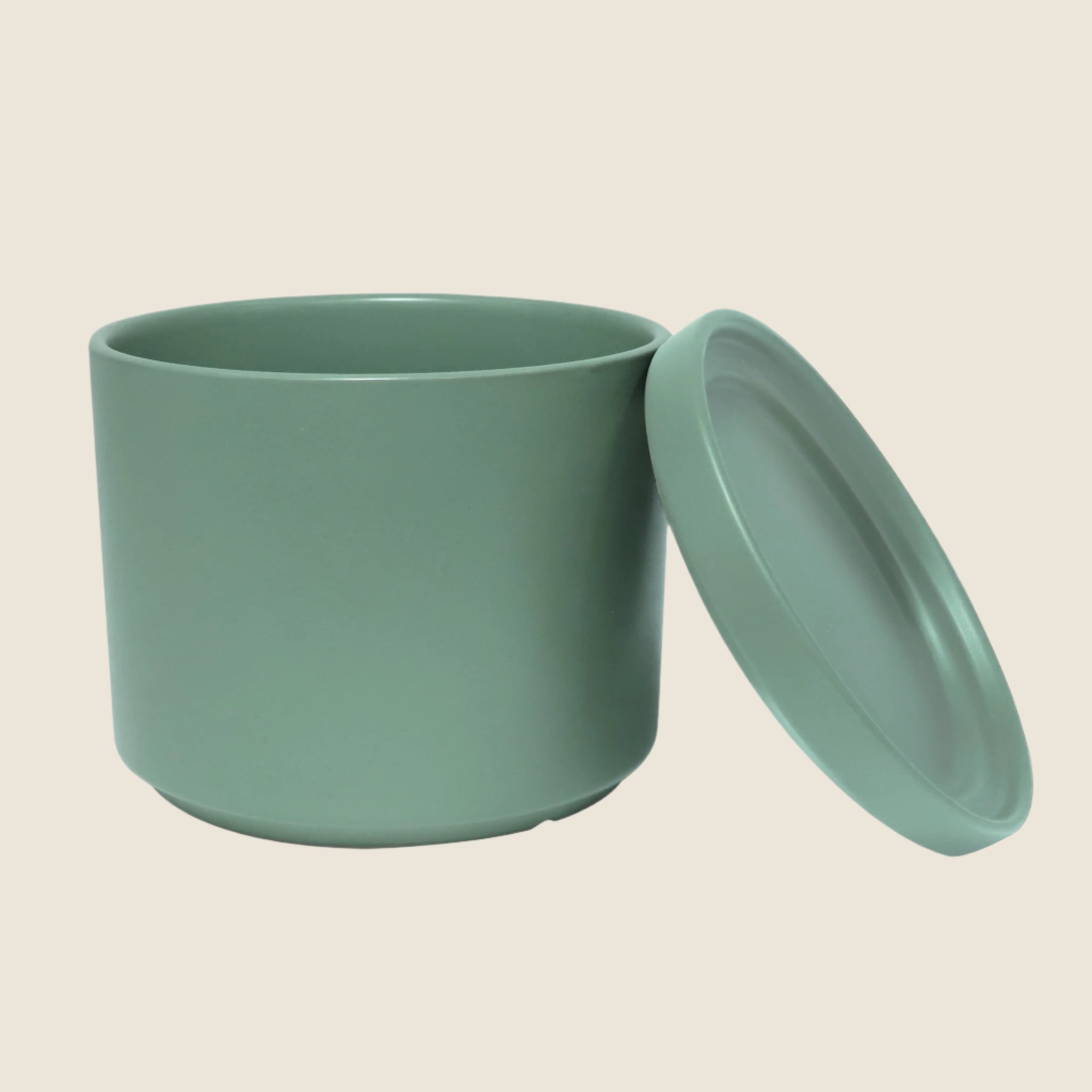 A green ceramic cylinder planter with removable saucers. Each planter sold separately.