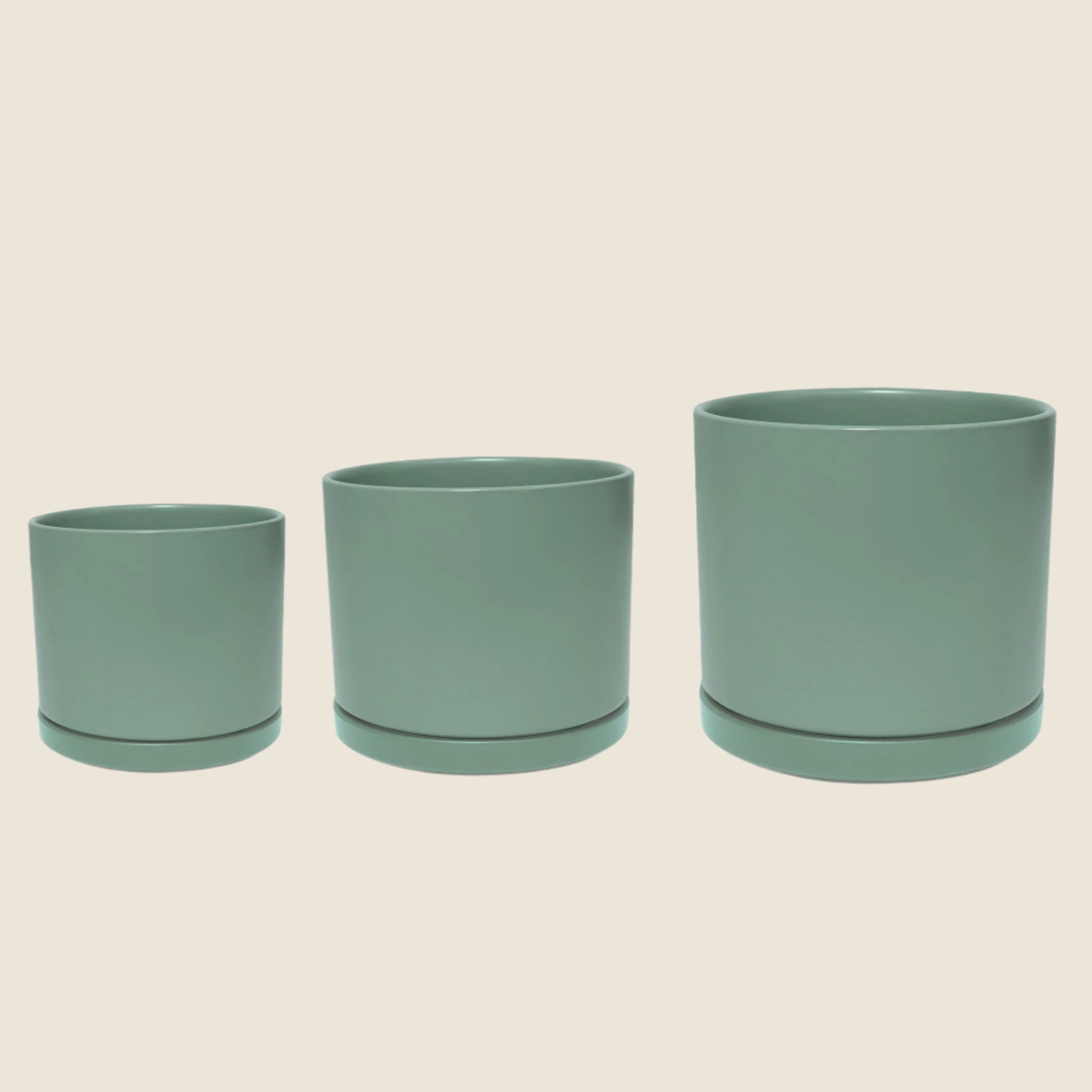 Green ceramic cylinder planters with removable saucers. Each planter sold separately. 