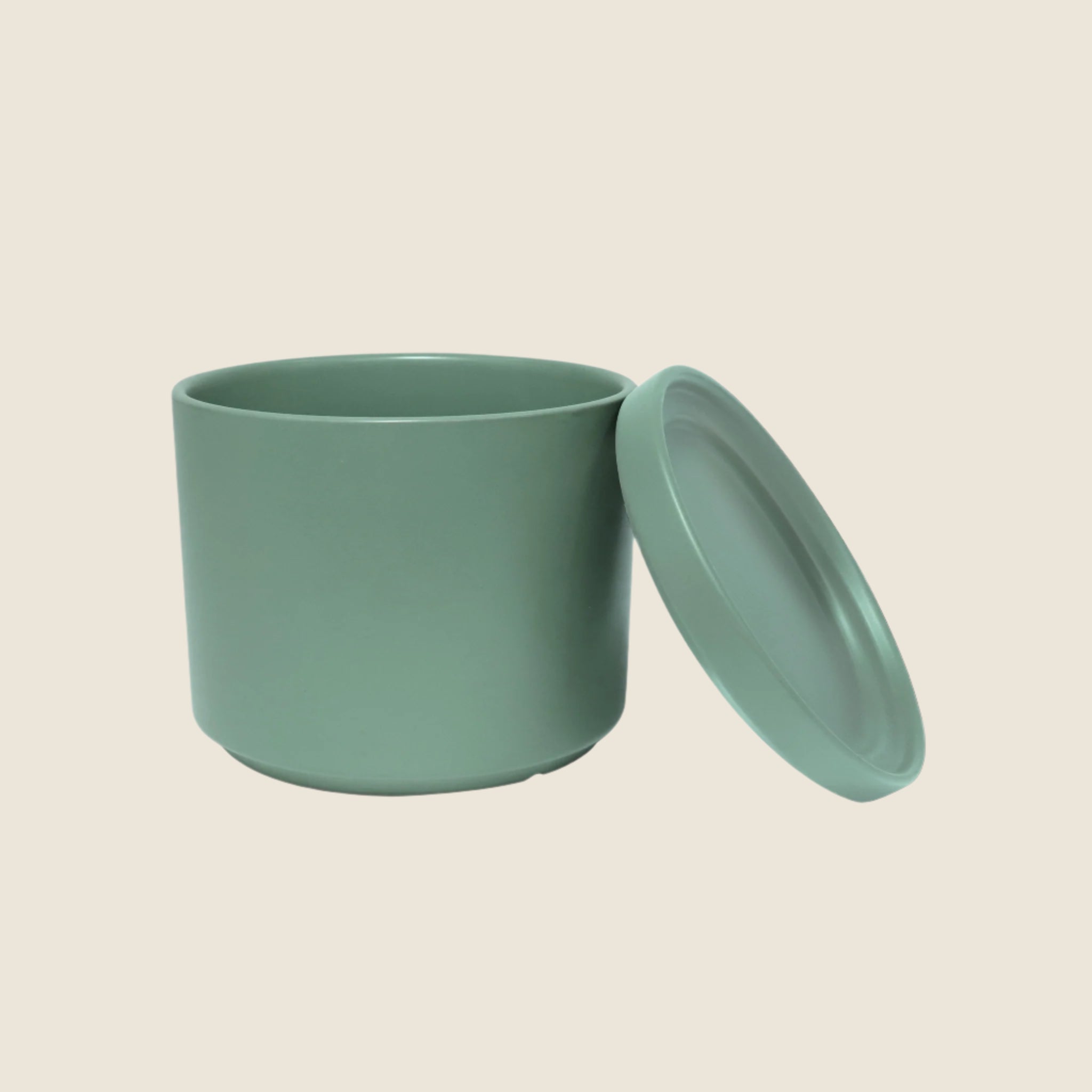 A green ceramic cylinder planter with removable saucers. Each planter sold separately. 