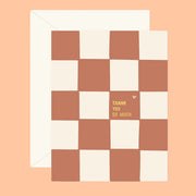 An ivory and terracotta brown checker print card with gold text that reads, "Thank You So Much". 