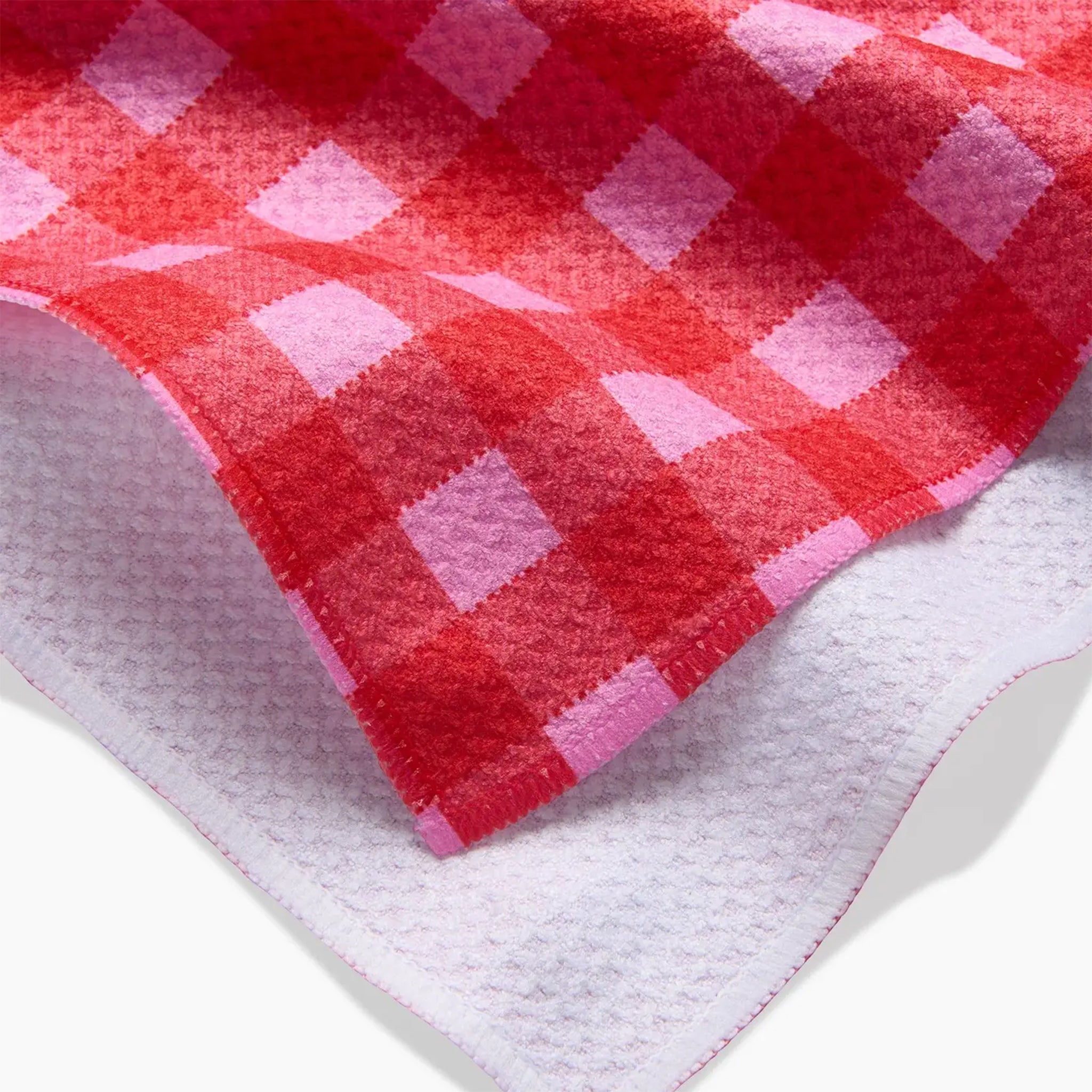 A red and pink gingham print tea towel with a waffle weave.