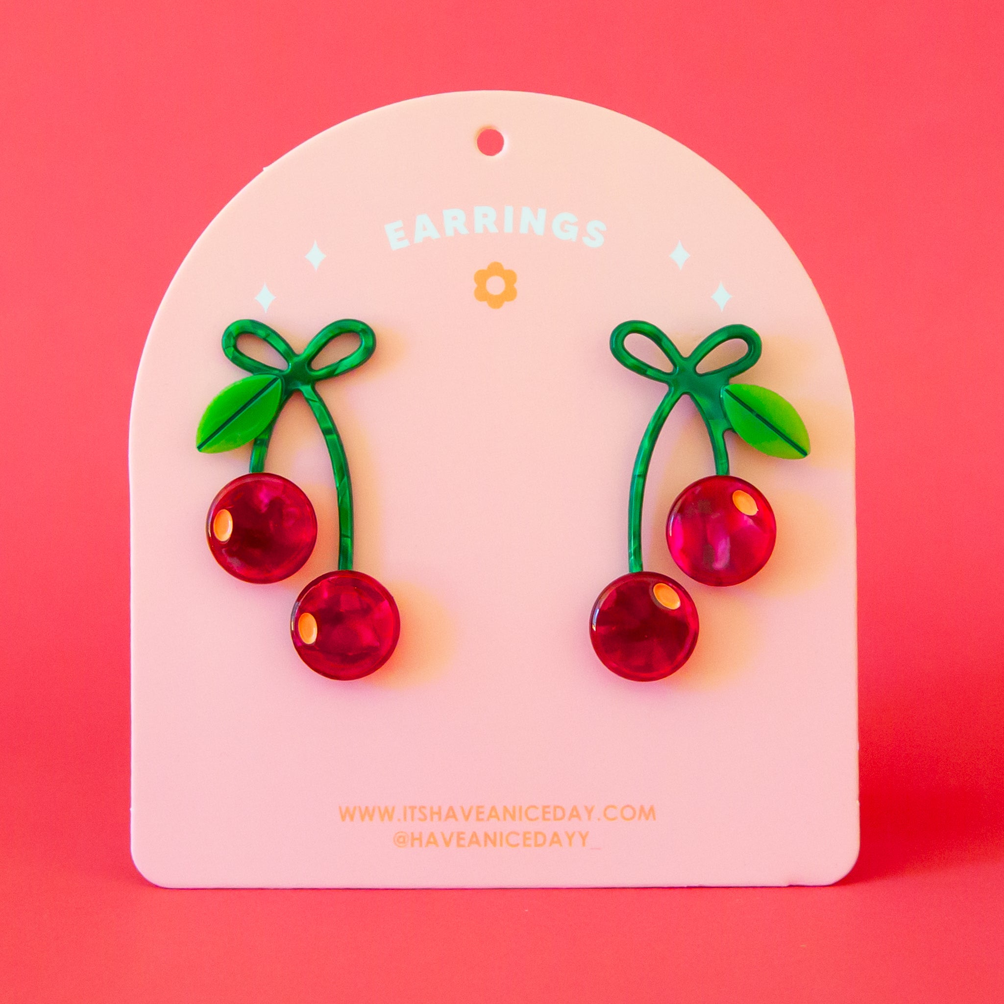 A pair of red and green cherry shaped earrings. 