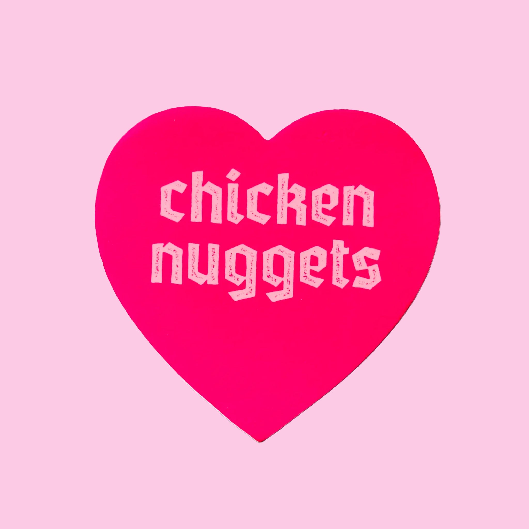 A pink heart sticker that reads, "chicken nuggets". 