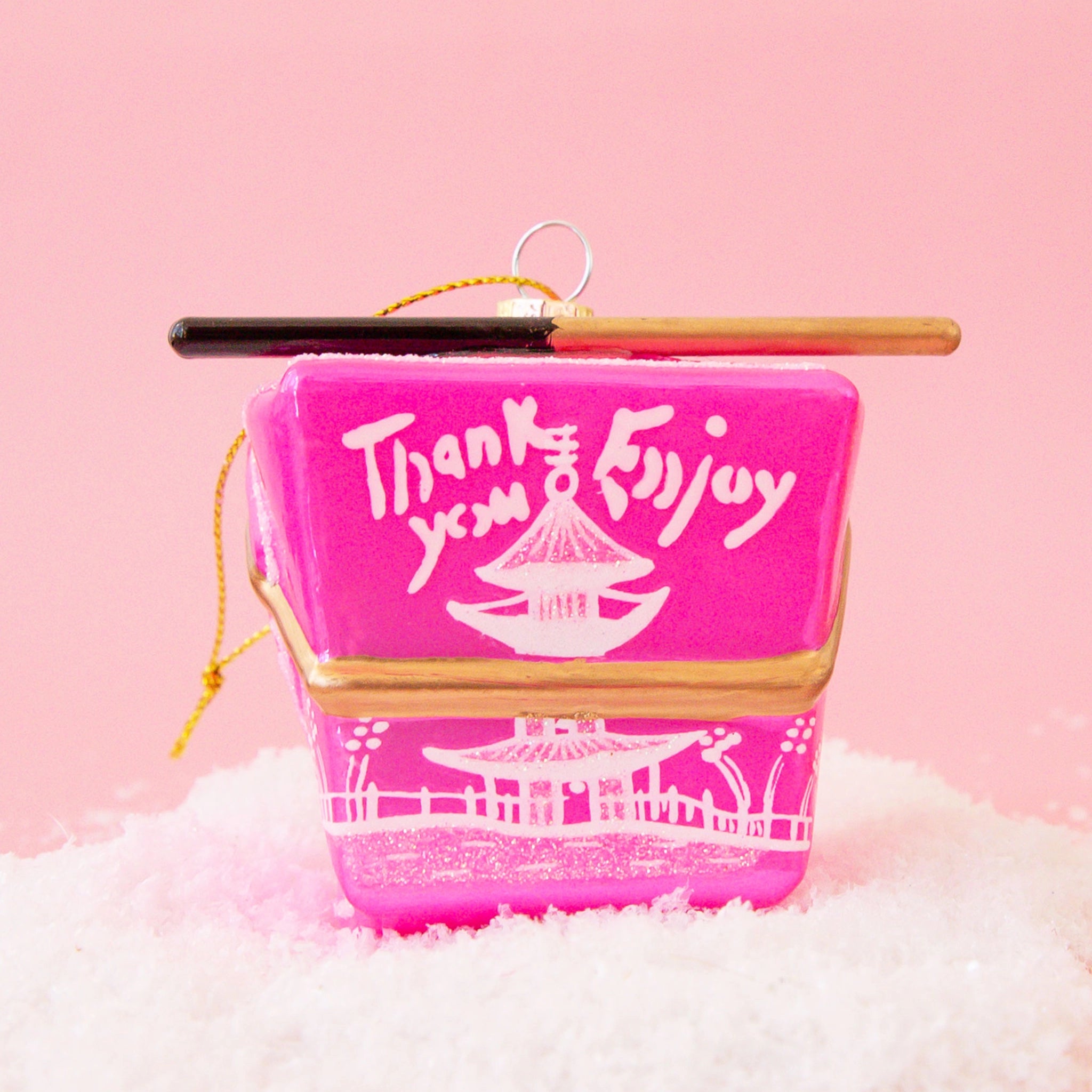 A pink glass ornament made to look like a Chinese to-go box with a pair of chopsticks across the top.