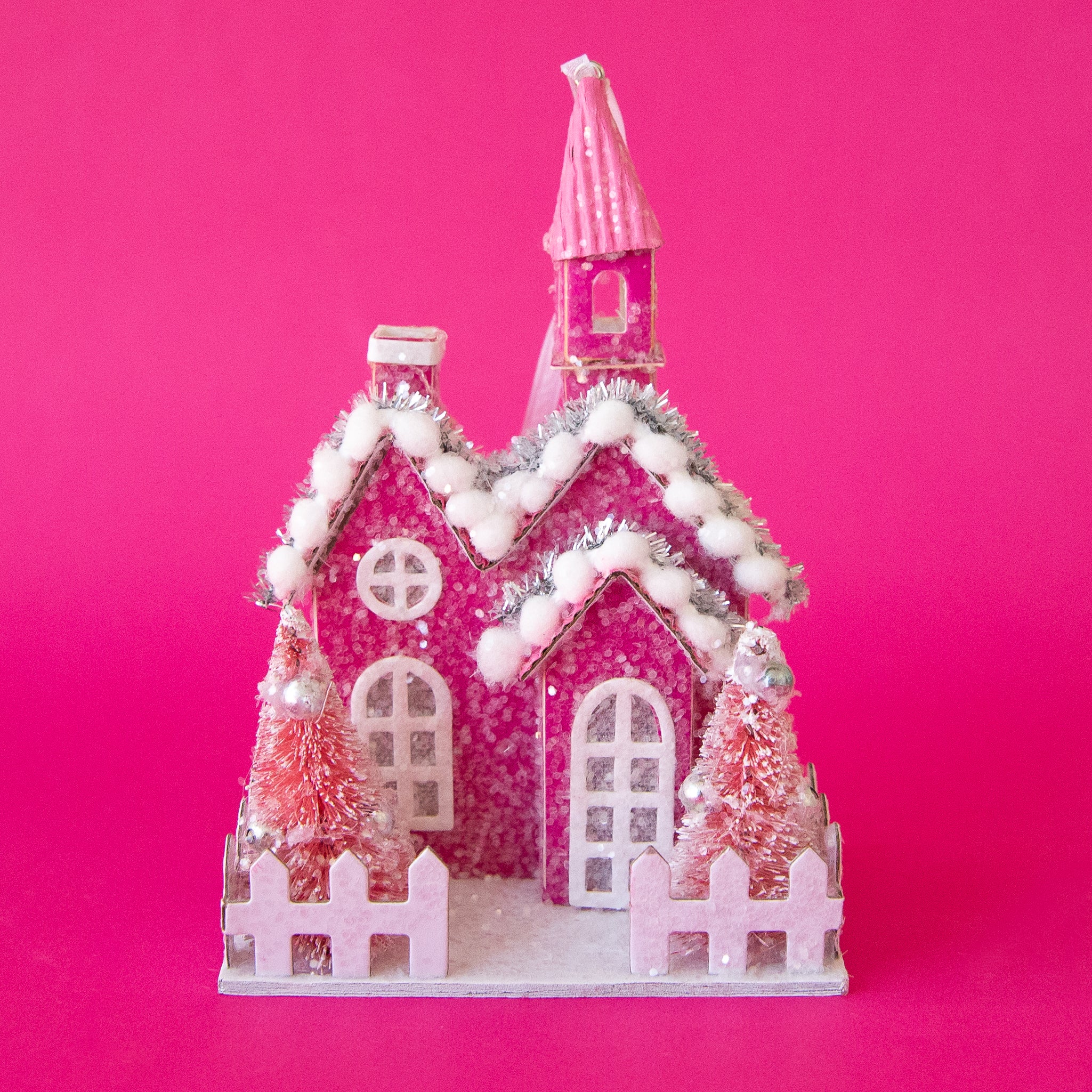 A church shaped ornament with with holiday decor details. 